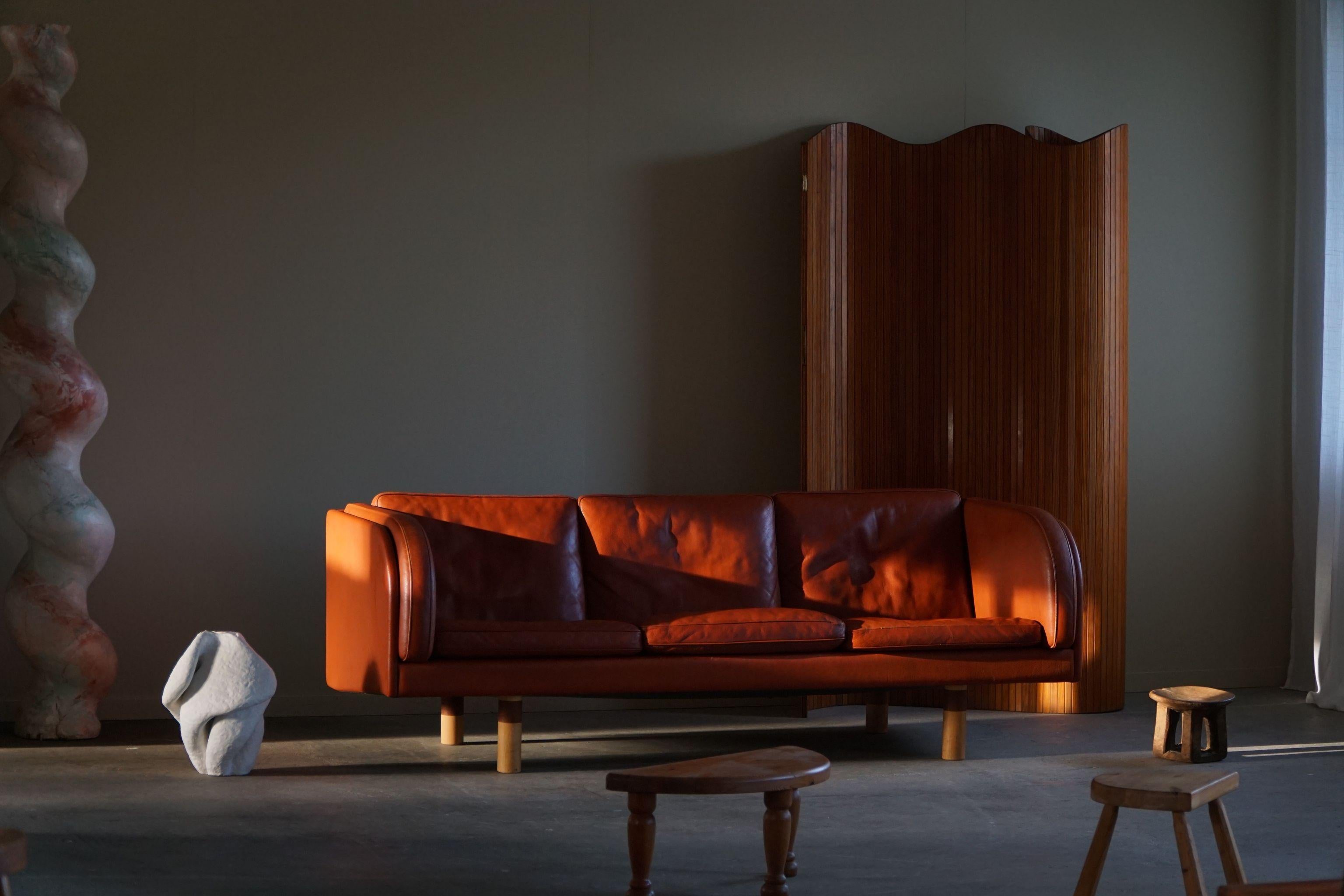 This charming 3-seater Sofa, Model EJ-20-3, designed by Jørgen Gammelgaard for Erik Jørgensen in the 1970s, embodies the essence of Danish Mid Century Modern design. Upholstered in vibrant red leather, the sofa exudes a timeless and elegant