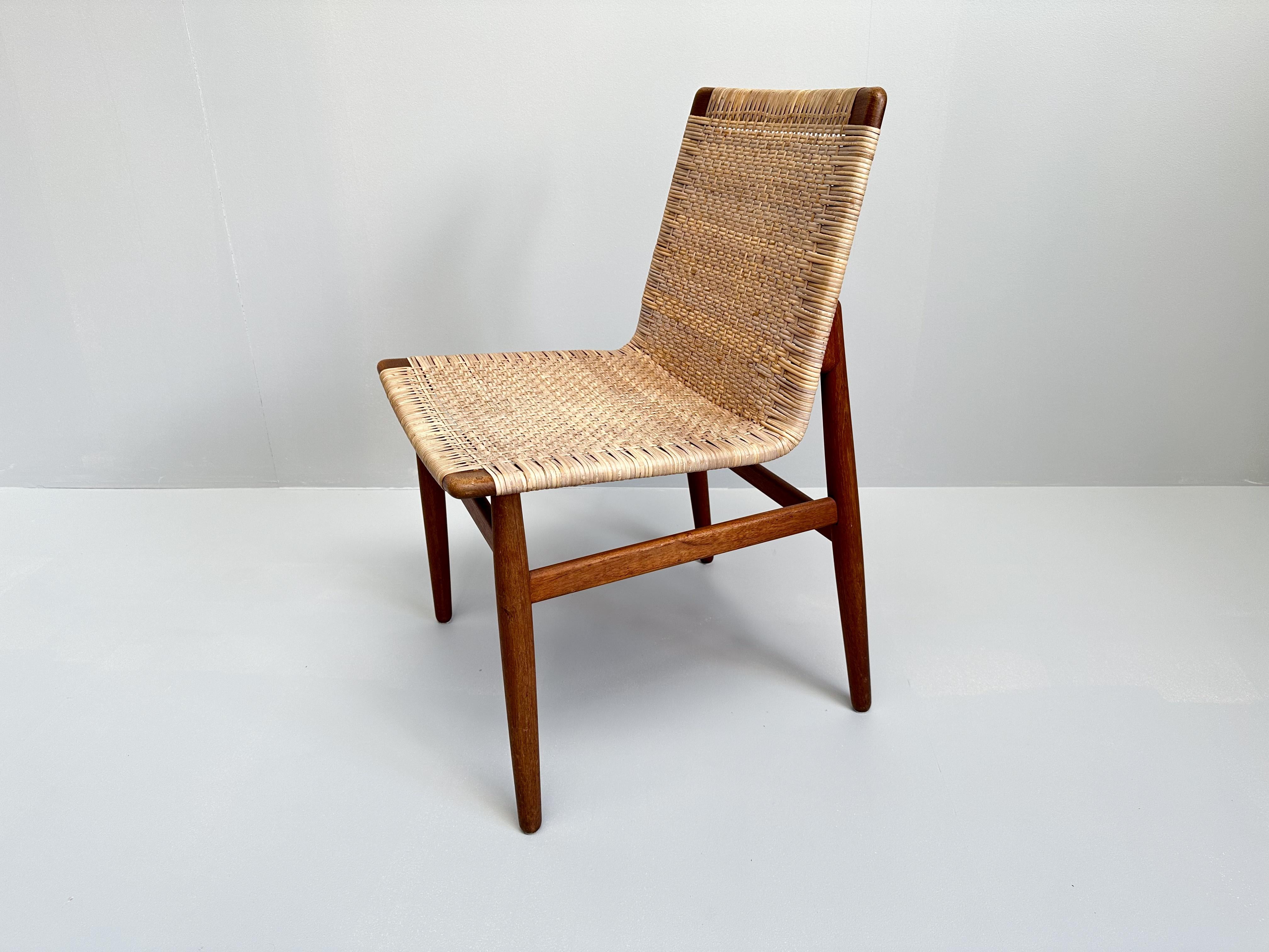 This very rare teak and rattan chair, designed by Jørgen Høj and produced by Thorald Madsen in Copenhagen during the 1950s, is a fine example of Danish modern design. Crafted from warm solid teak combined with light woven rattan, it embodies the