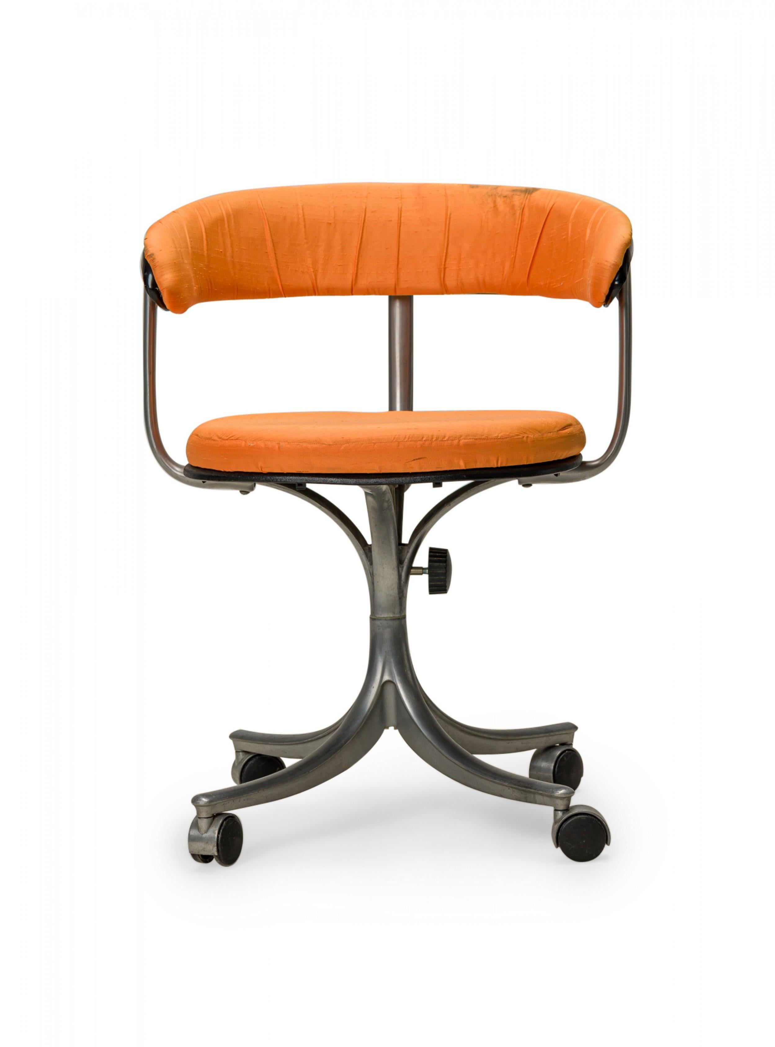 Danish Mid-Century rolling / swivel office chair with a U-shaped back and orange fabric seat and back upholstery, supported by a matte silver metal frame and pedestal base with four legs and four casters. (JØRGEN RASMUSSEN)
