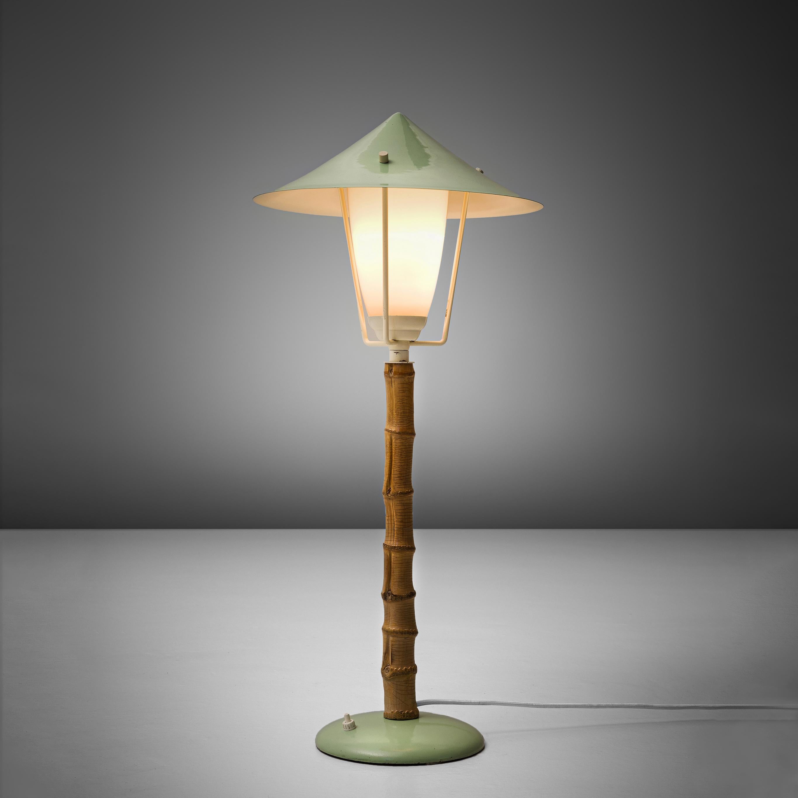 J.T. Kalmar, table lamp, metal, faux-bamboo and glass, Austria, 1950s. 

Frivolous table lamp, or small floor lamp in green coated metal. Overall, this lamp reminds of a tradition garden light. The garden is literally represented in this light by
