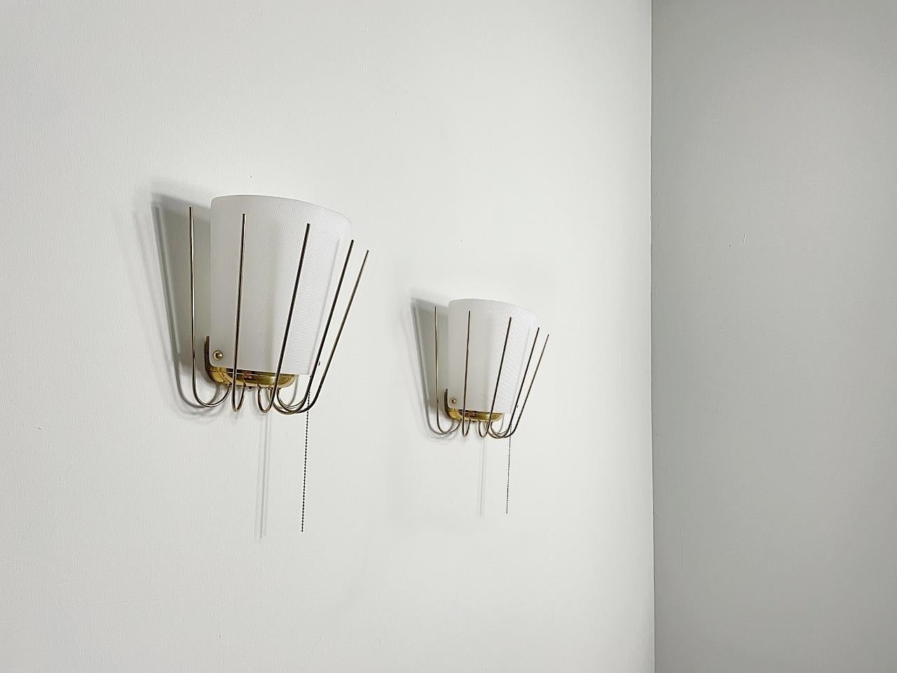 Beautiful Modernist wall sconces made by J. T. Kalmar in the 1950s. The light is made of polished brass and the lampshades are made of acrylic glass. The faceted acrylic glass provides a smooth large-area light.
Fully rewired, working and tested