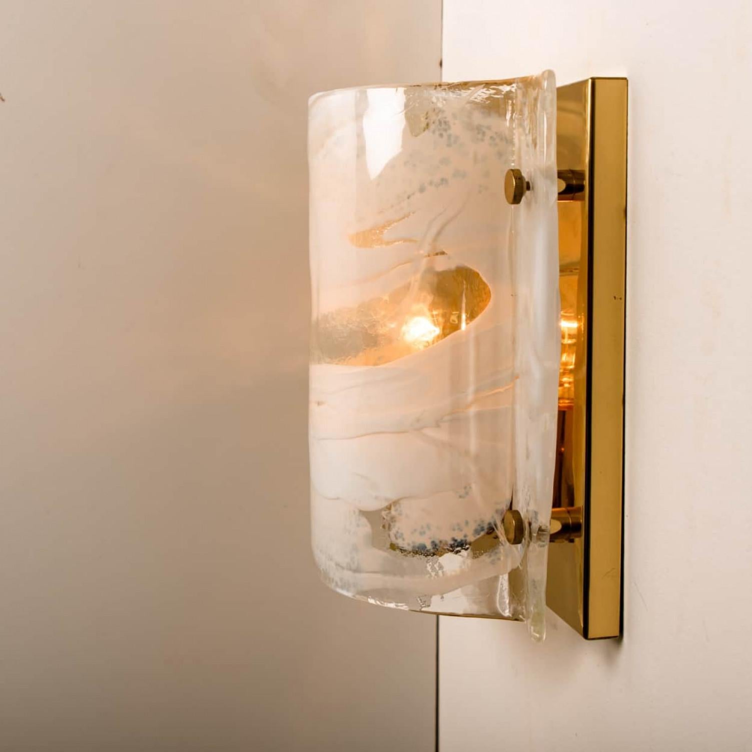 Elegant J.T. Kalmar wall sconces featuring thick white and clear swirl glass on a gilded brass base. Manufactured by the company Kalmar in Austria, Europe around 1960.
Minimalistic design executed with a taste for excellence in craftsmanship.
