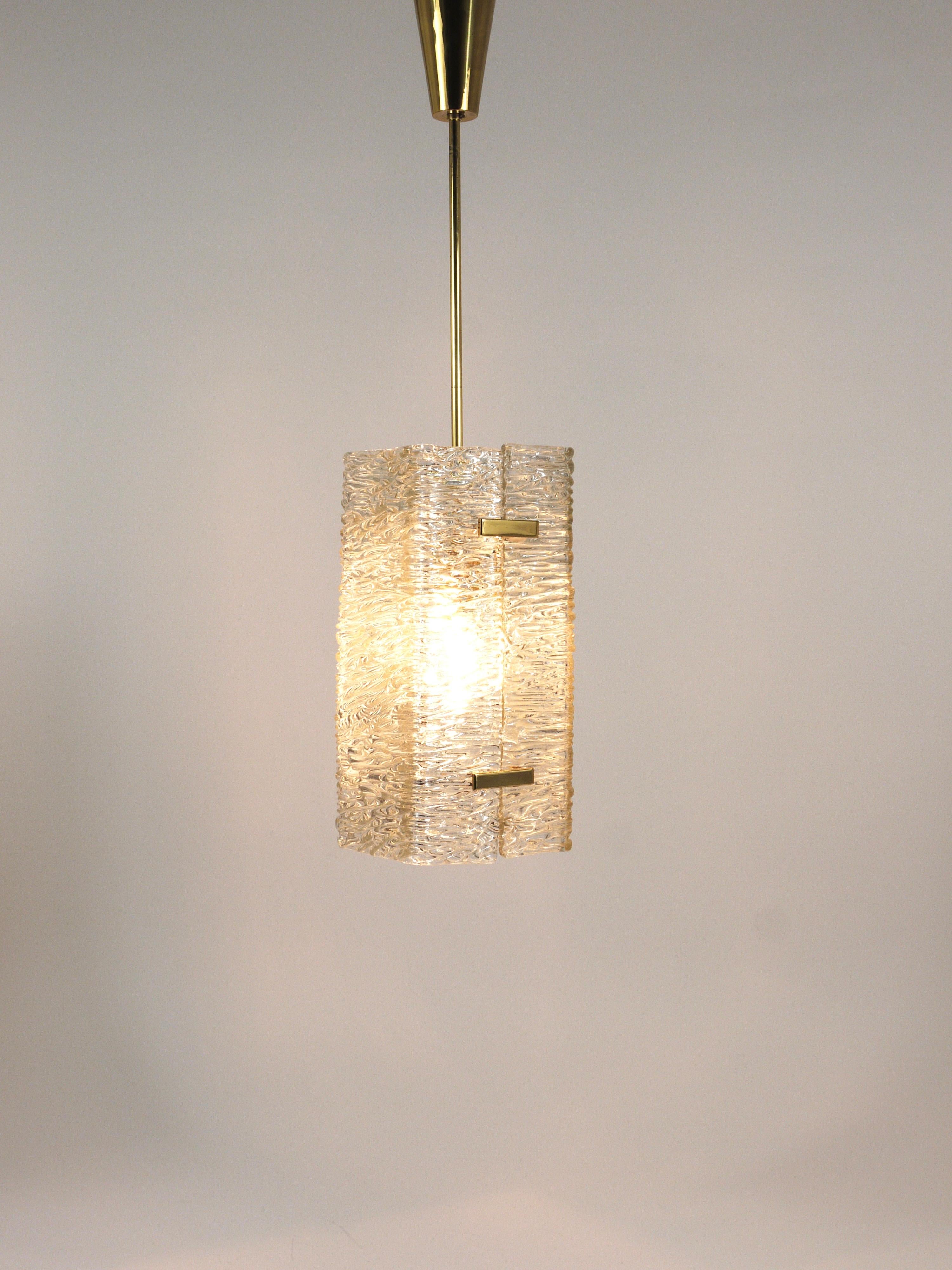 This is a beautiful Mid-Century chandelier / pendant light from the 1950s, crafted by J.T. Kalmar in Vienna, Austria. The chandelier features brass and white-painted metal hardware, complemented by two thick, textured 