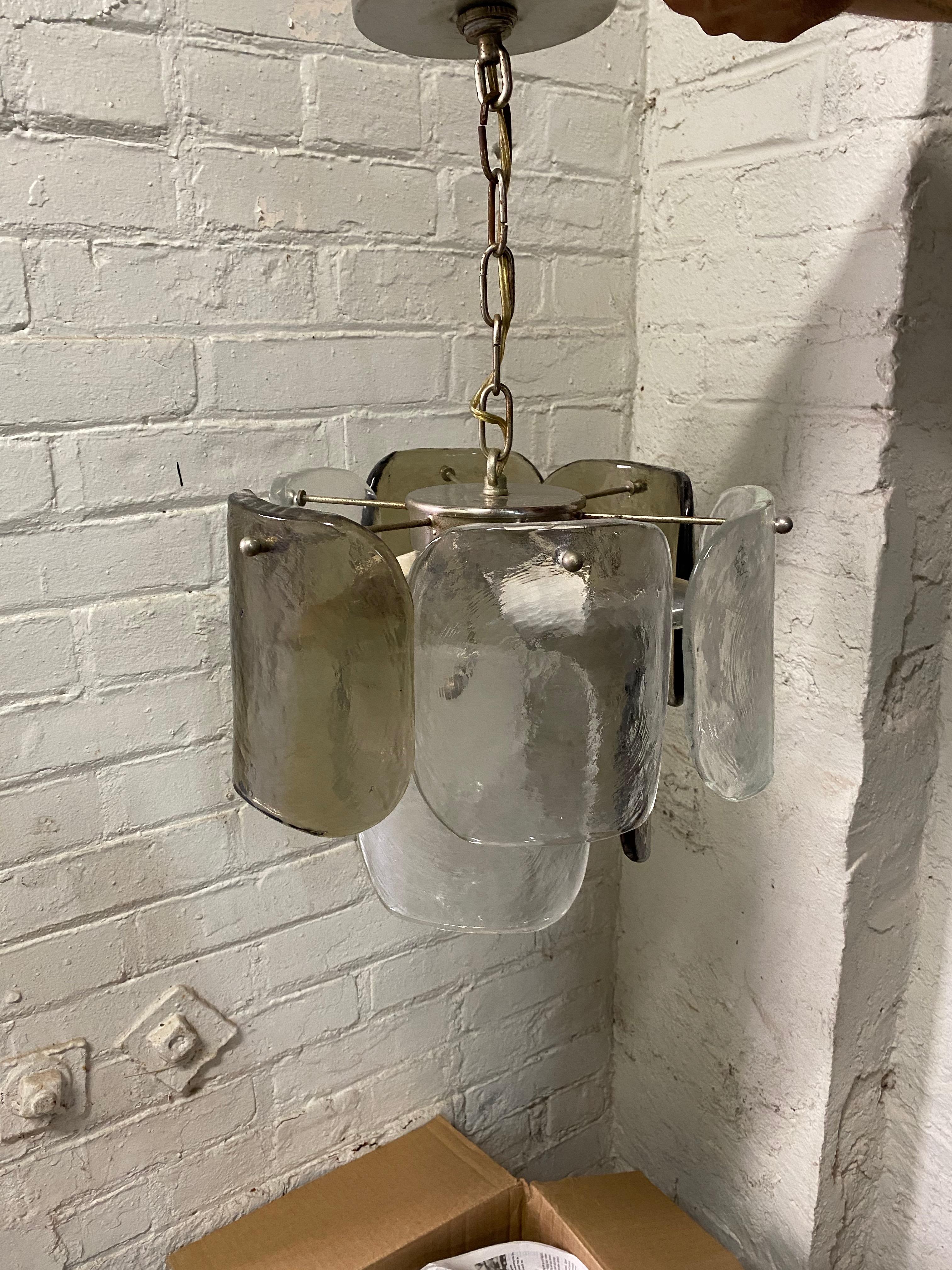 J.T. Kalmar, Italy smoke and clear glass nine panel chandelier, circa 1970. Wavey ice affect hanging curved glass panels. Four smoke gray and five clear glass. Three lights. Very good original condition with original working wiring.. Perfect accent