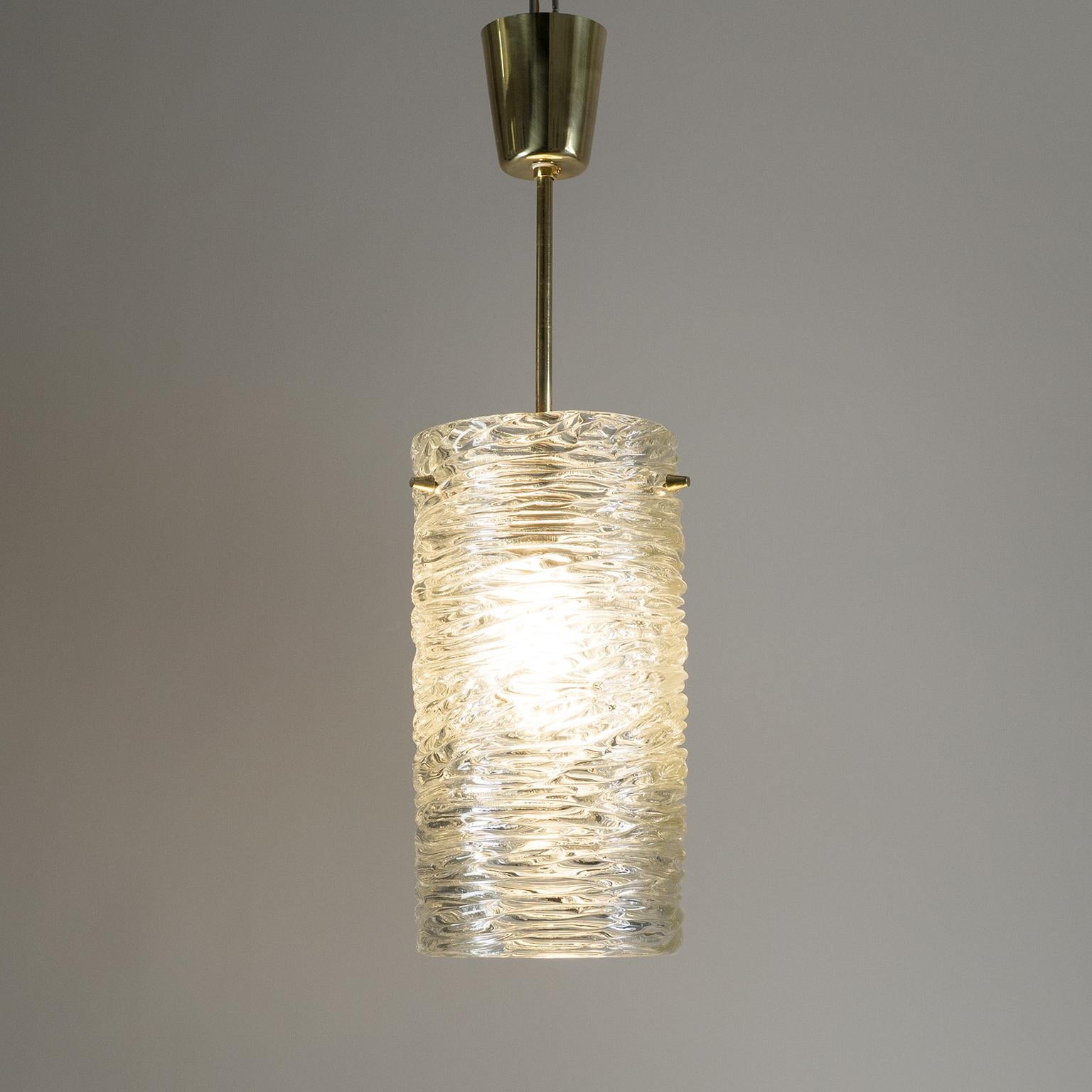 Classic 1950s J.T. Kalmar pendant with 'water-ripple' textured glass. Very good original condition with some light patina on the brass elements. One original brass E27 socket with new wiring. Height of the glass body is 11.5inches/30cm.