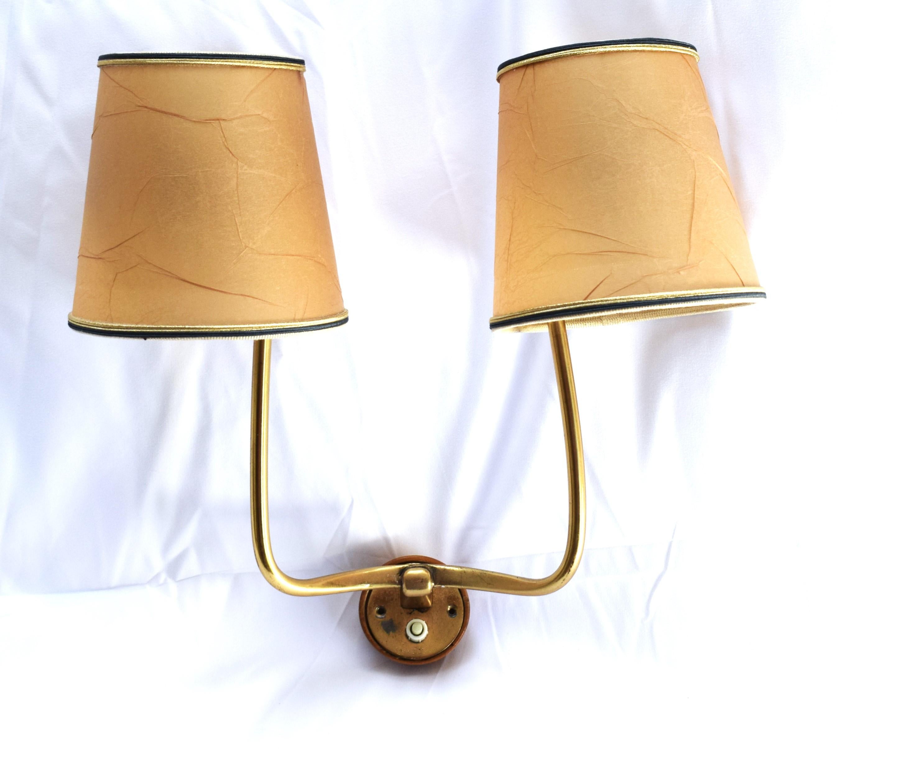 Lampada da parete a due luci del periodo Art Déco.
Lo stile e la maestria sono chiaramente riconducibili a J&T. Kalmar e Josef Frank.
Staffa originale in legno e paralume in pergamena.
2 prese E27