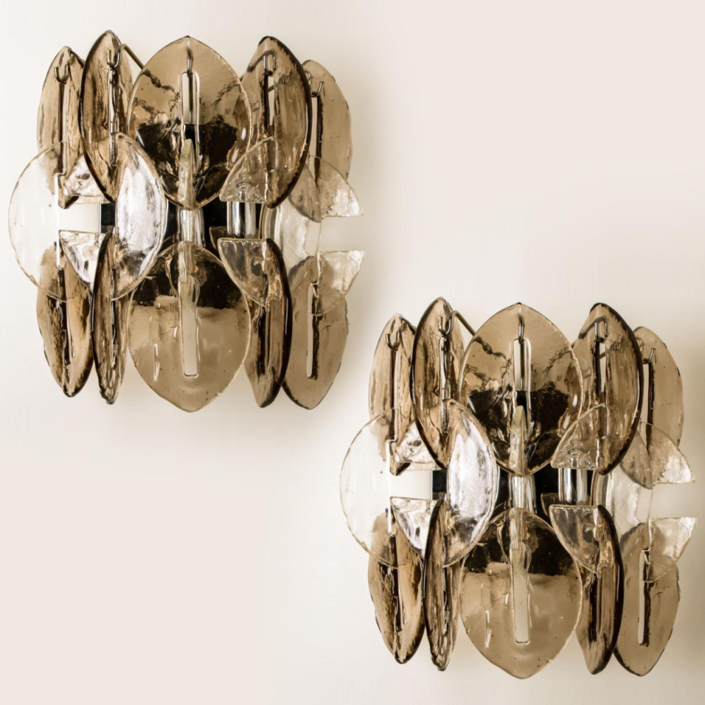 High-end and handmade chrome and glass wall lights made by Kalmar in Austria, Europe around 1970. The light consists of 14 glass discs, in both clear and smoked glass. The discs are hung on a chrome frame. These lights are executed to a very high