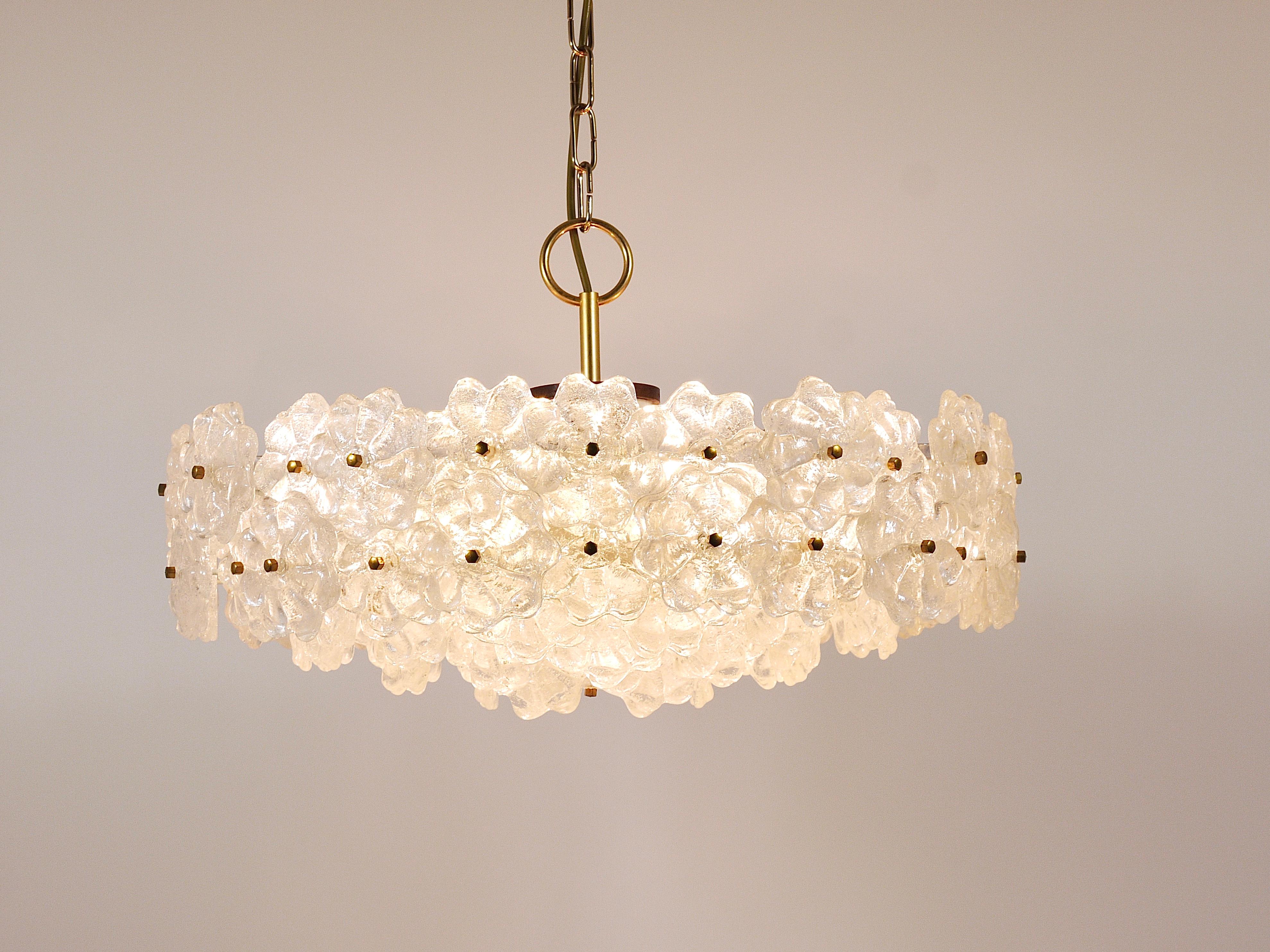A decorative floral 22“ diameter Midcentury Modern brass chandelier from the 1960s manufactured by J.T. Kalmar Vienna, Austria. Its frame is made of white painted metal, it has four tiers covered with lovely lucite acrylic „melting glass