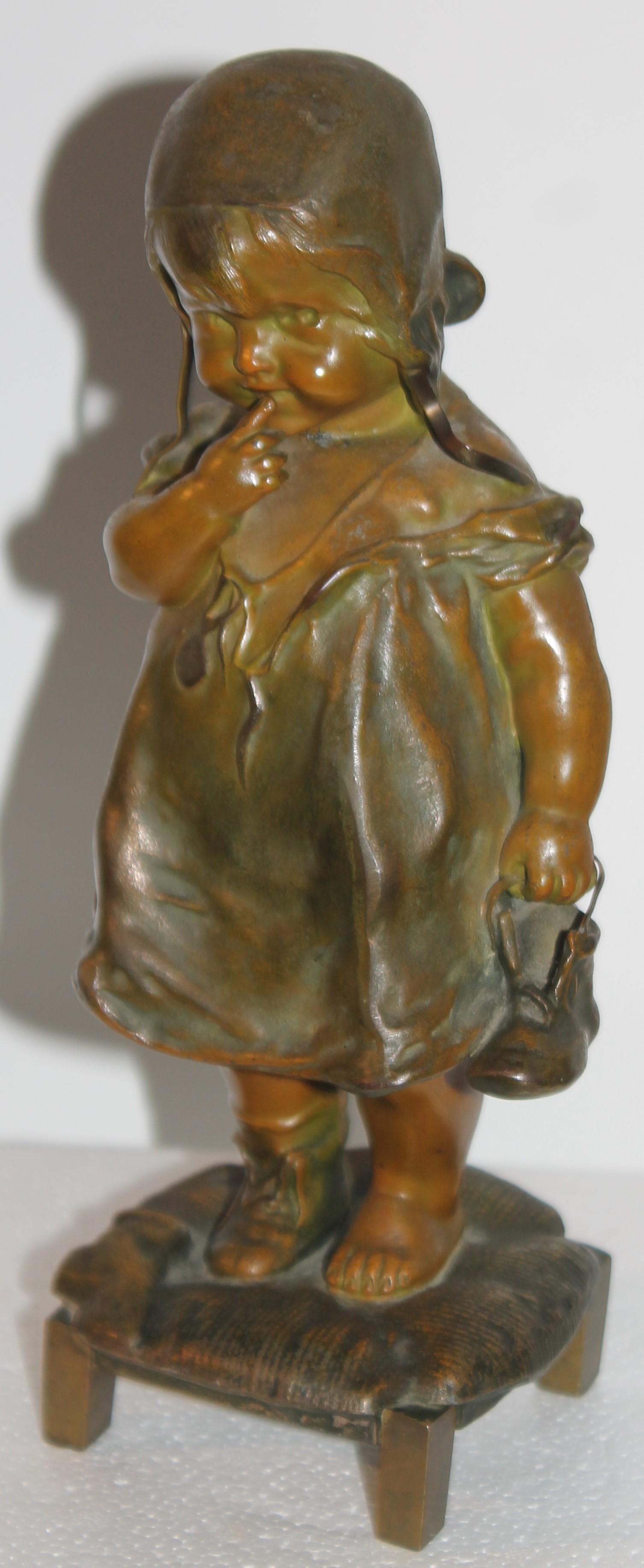 Juan Clara Art Noveau girl on stool sculpture holding shoe in hand. This bronze has great weight and a great look. The sculpture of the young girl is holding a shoe in one hand while the opposite foot has the shoe on. She is standing on a stool and