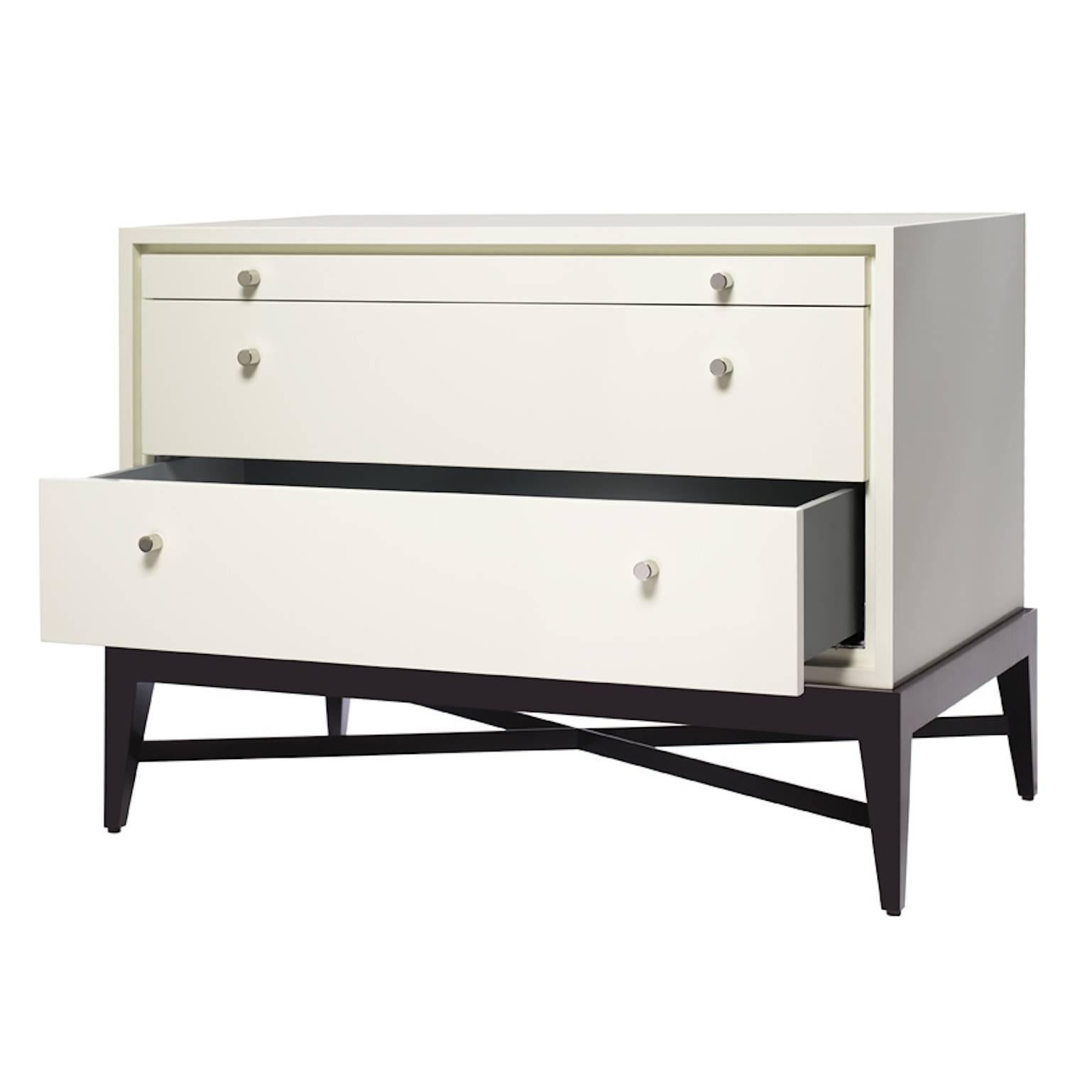 Wood or lacquer two-drawer chest with glass inset pullout tablet, metal pulls and show-wood base with tapered legs and X-stretcher. Lacquer drawer and tablet interiors.

As shown: Chalk white lacquer cabinet, slate lacquer interior, chocolate