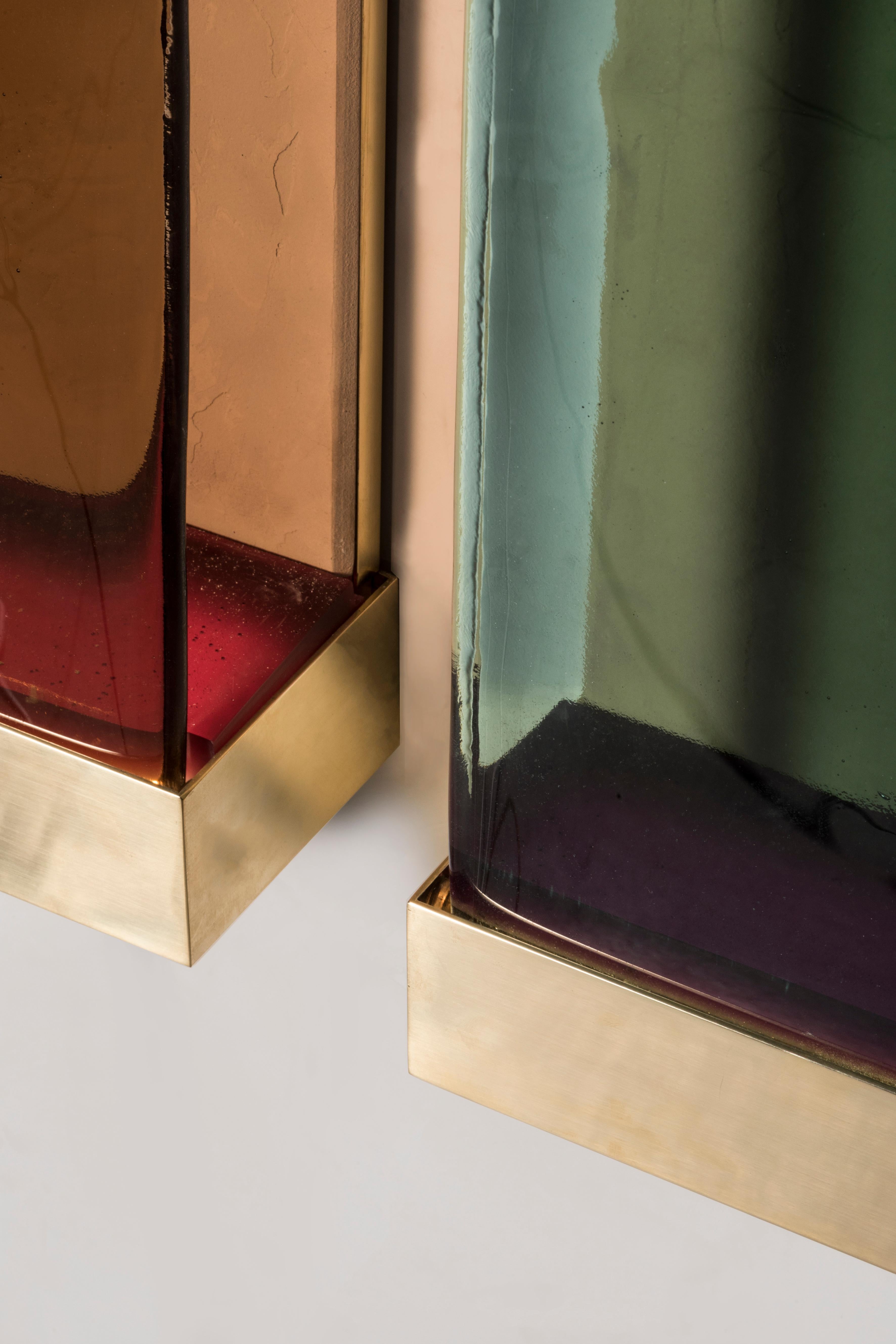 Drawing inspiration from minimalism, Jud lamps pay tribute to artist Donald Judd. The various shades of translucent glass and resin filters have been melded together to create a cohesive and balanced color scheme. Each piece consists of a brass