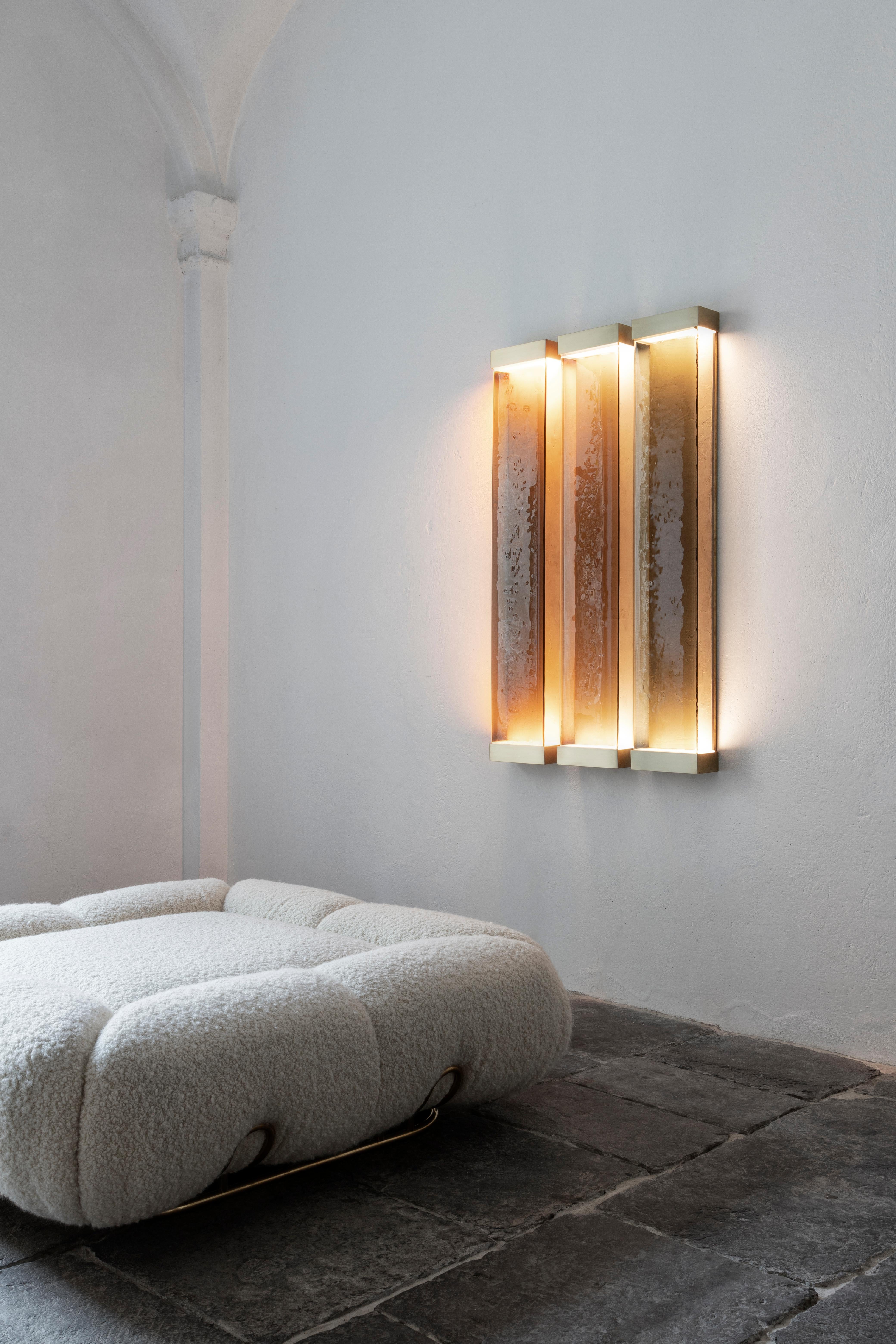 Drawing inspiration from minimalism, Jud lamps pay tribute to artist Donald Judd. The various shades of translucent glass and resin filters have been melded together to create a cohesive and balanced color scheme. Each piece consists of a brass