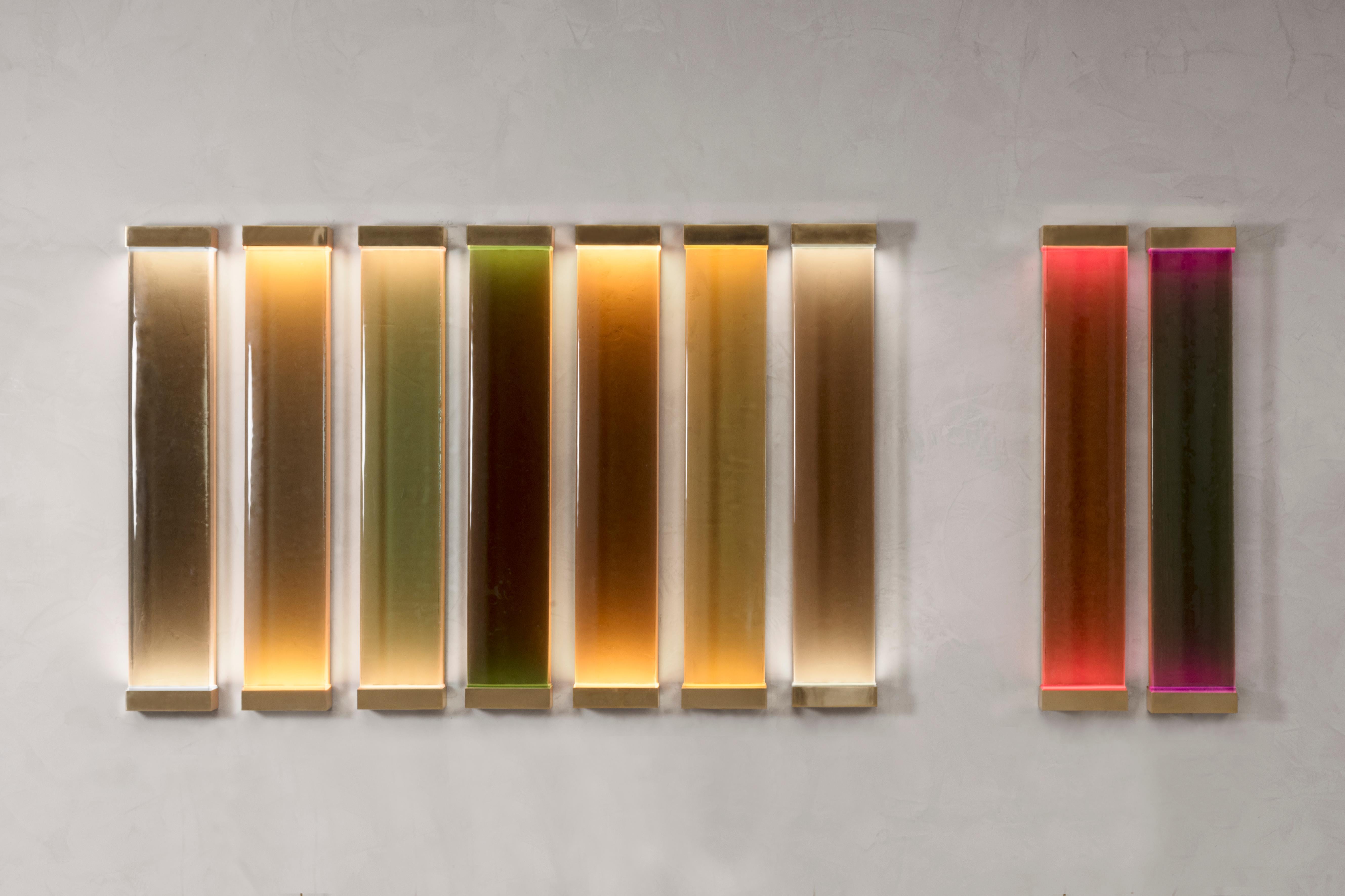 Drawing inspiration from minimalism, Jud lamps pay tribute to artist Donald Judd. The various shades of translucent glass and resin filters have been melded together to create a cohesive and balanced color scheme. Each piece consists of a brass