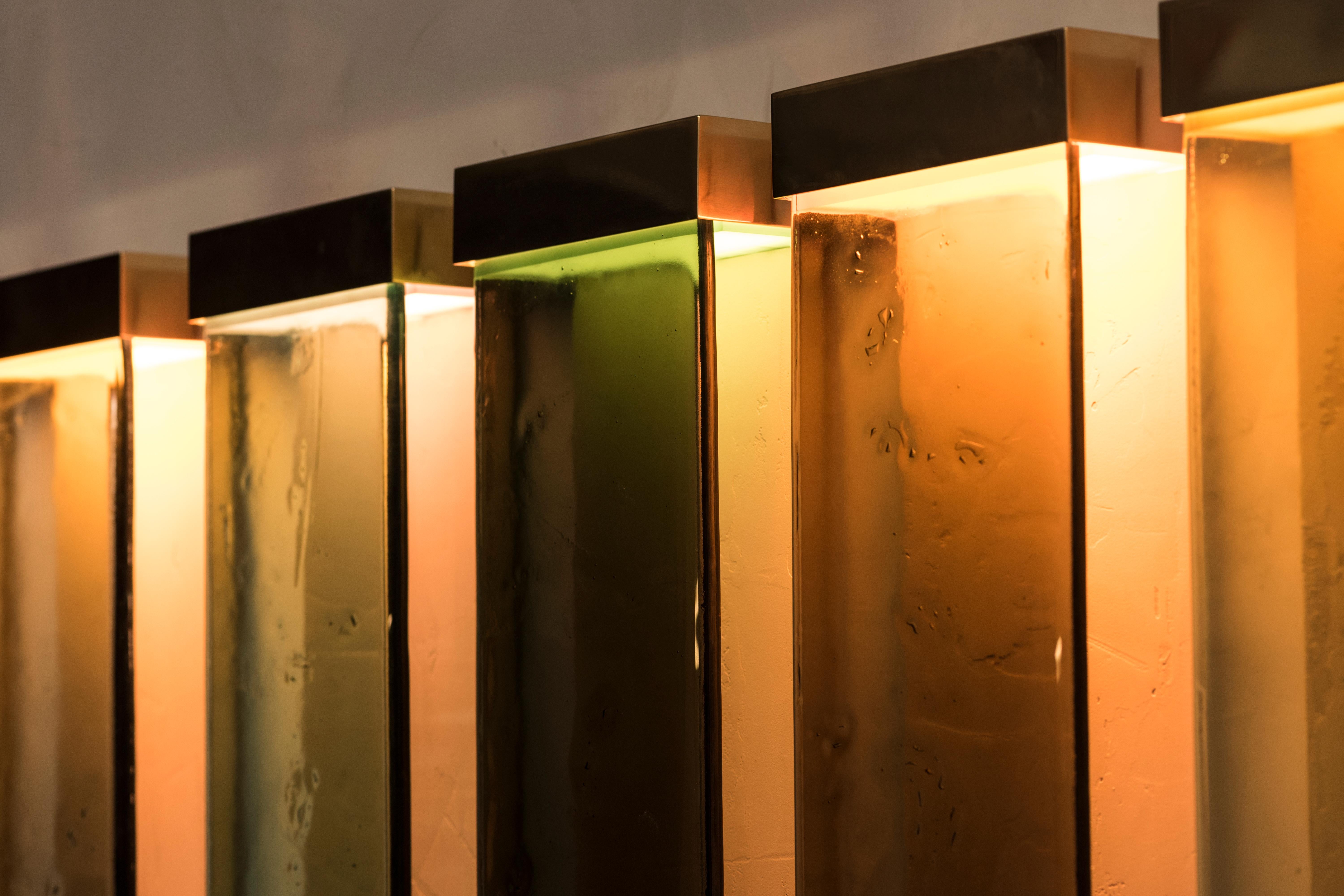 Die vom Minimalismus inspirierten Jud-Lampen sind eine Hommage an den Künstler Donald Judd. Die verschiedenen Schattierungen der lichtdurchlässigen Glas- und Harzfilter wurden zu einem kohärenten und ausgewogenen Farbschema verschmolzen. Jedes Stück