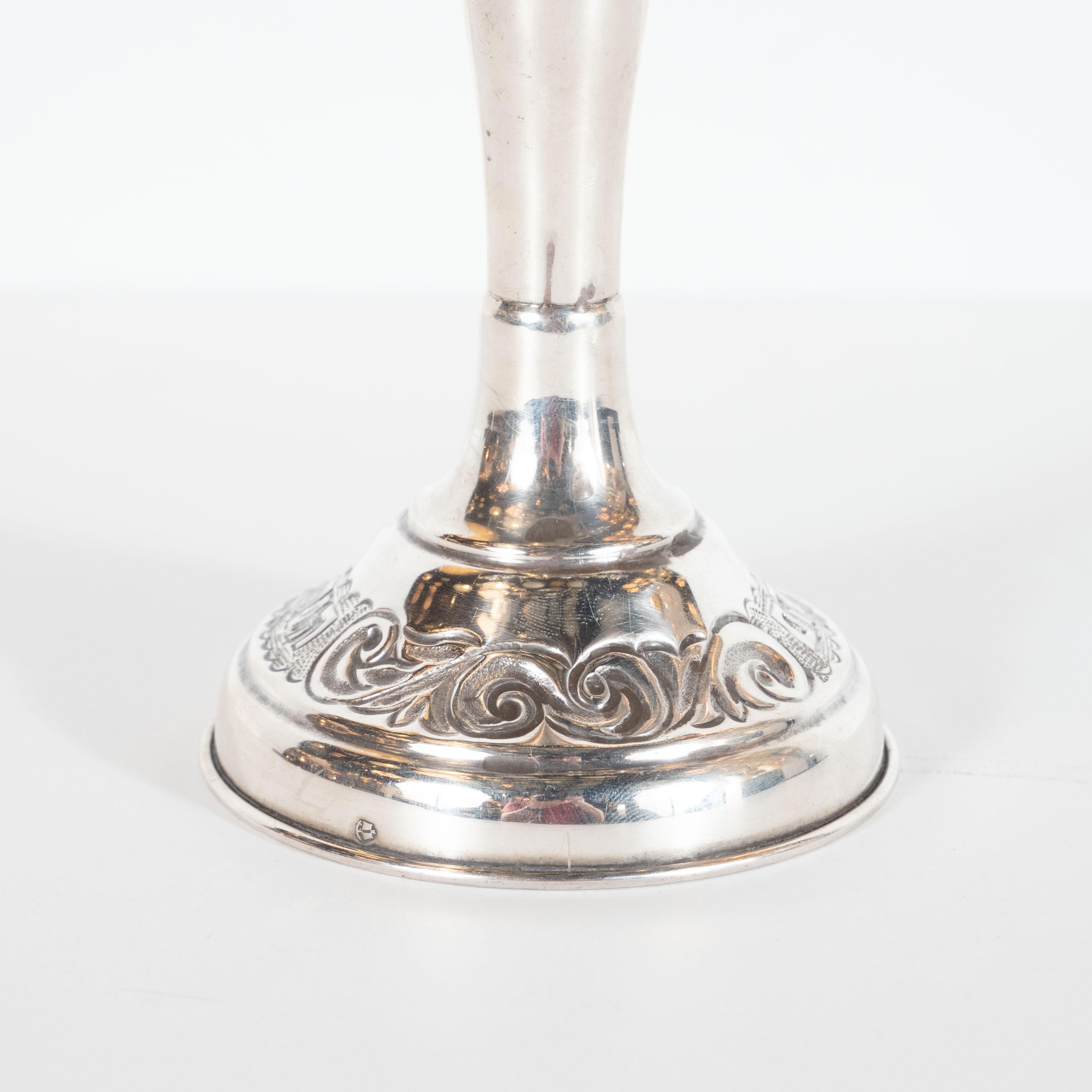 This elegant Art Deco white metal menorah was crafted by hand in the United States, circa 1930. It offers a stepped base- consisting of a slightly inclined band that adjoins a convex tier with a hand hammered chanukah prayer in hebrew inscribed