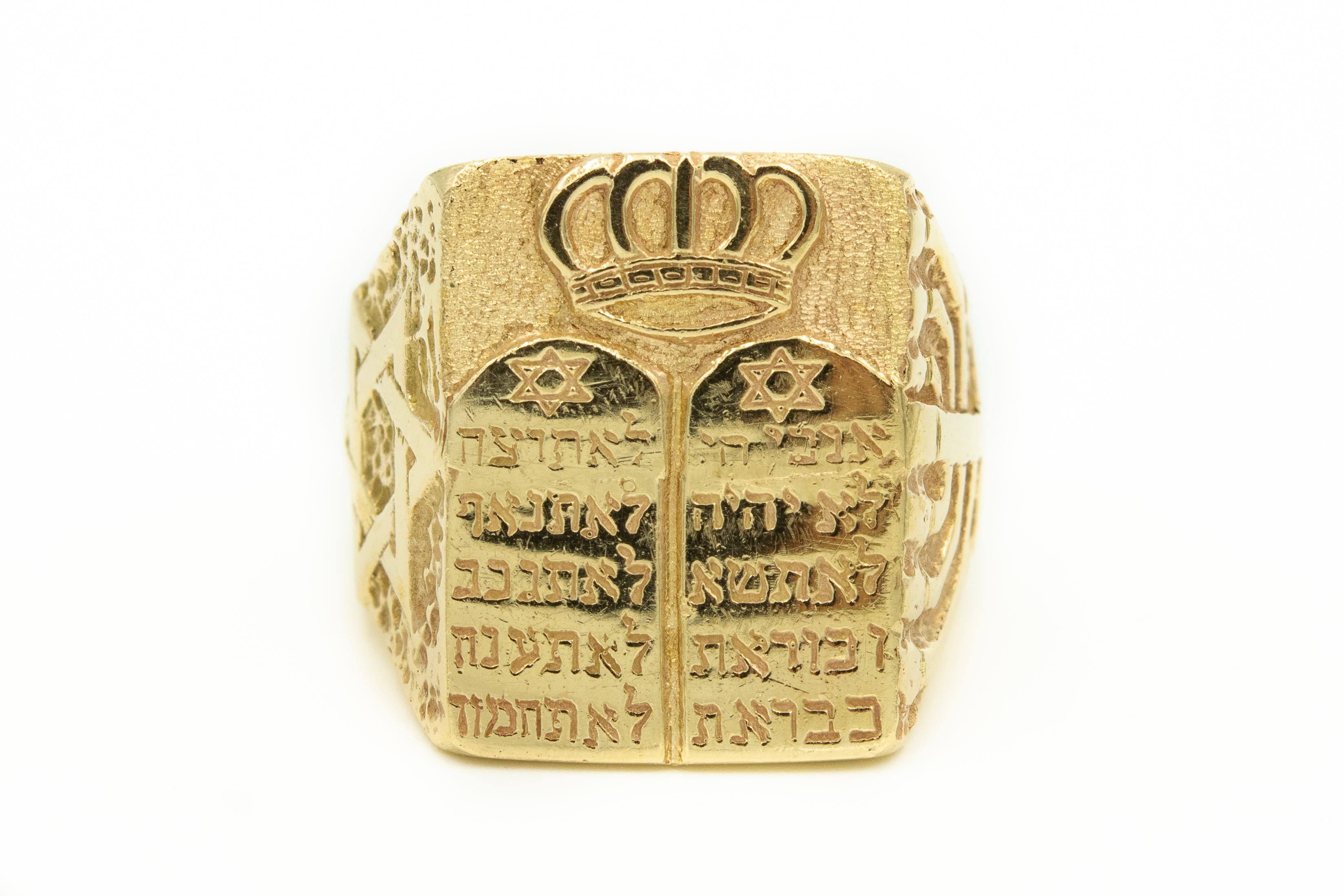 This 14k yellow gold ring was custom made by Spitzer & Furman for a prominent Miami Beach Rabbi in the 1960's.  The front of the ring has the Ten Commandments and a Torah Crown.  On one side has the Star of David and the other side has a Menorah. 