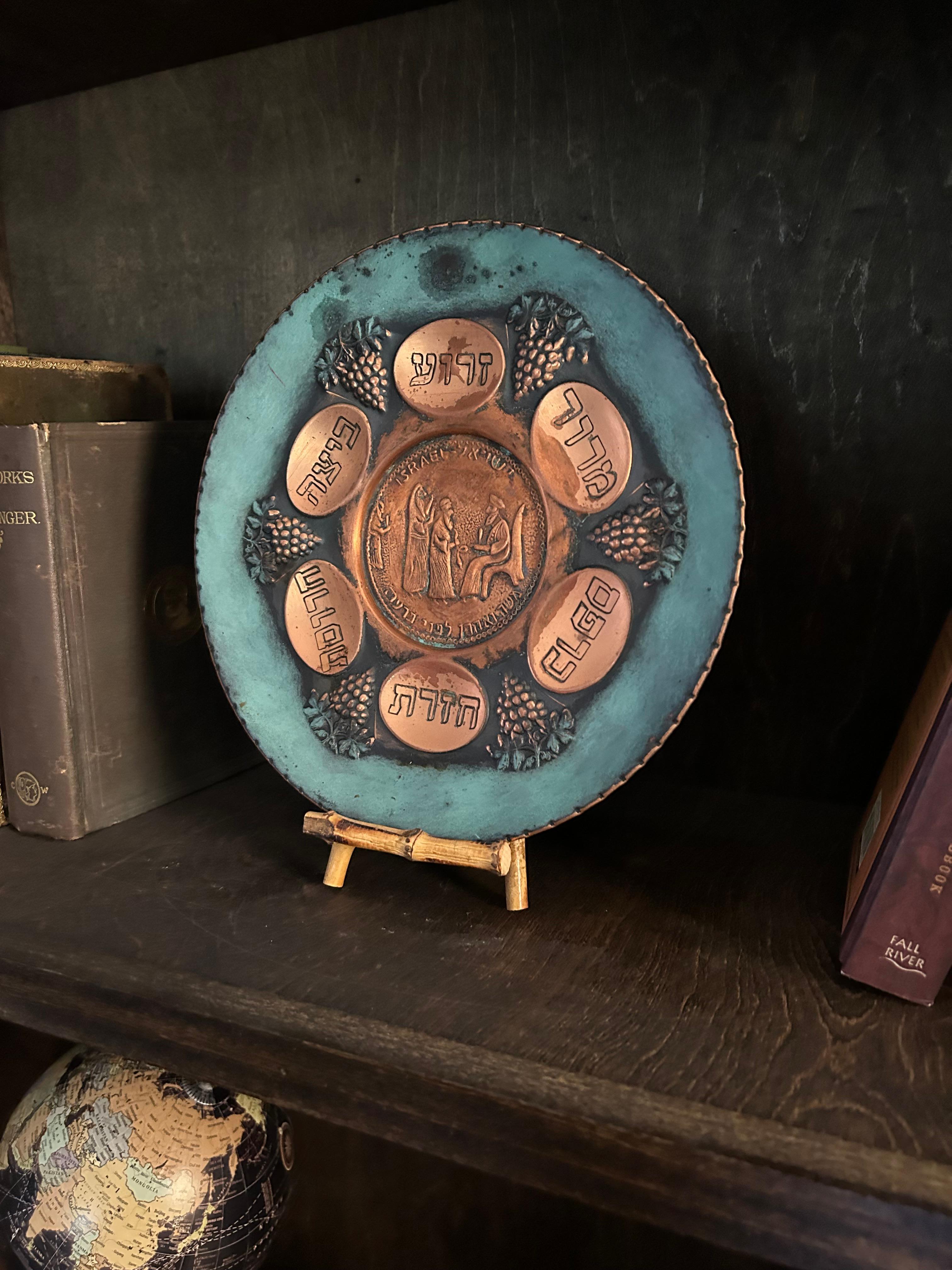 Vintage Judaica Passover Seder plate in copper and metal. The items for the plate are in Hebrew and are etched in. Grapes going around are raised. Center depicts Moses and Aaron before the Pharoah (states in Hebrew, Moshe veAharon lephnai Paroh) and