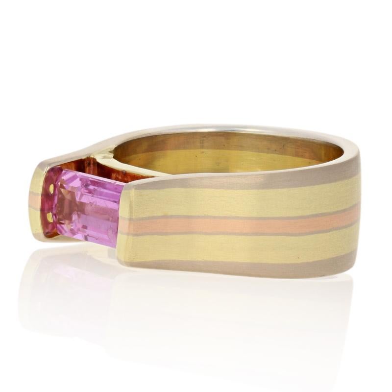 Celebrating lines, form, and color, this exquisite piece of wearable art is sure to inspire your creative side! This Jude Frances ring hosts a radiant pink sapphire cradled in a sleek 18k yellow, white, and rose gold striped mount. The ring’s