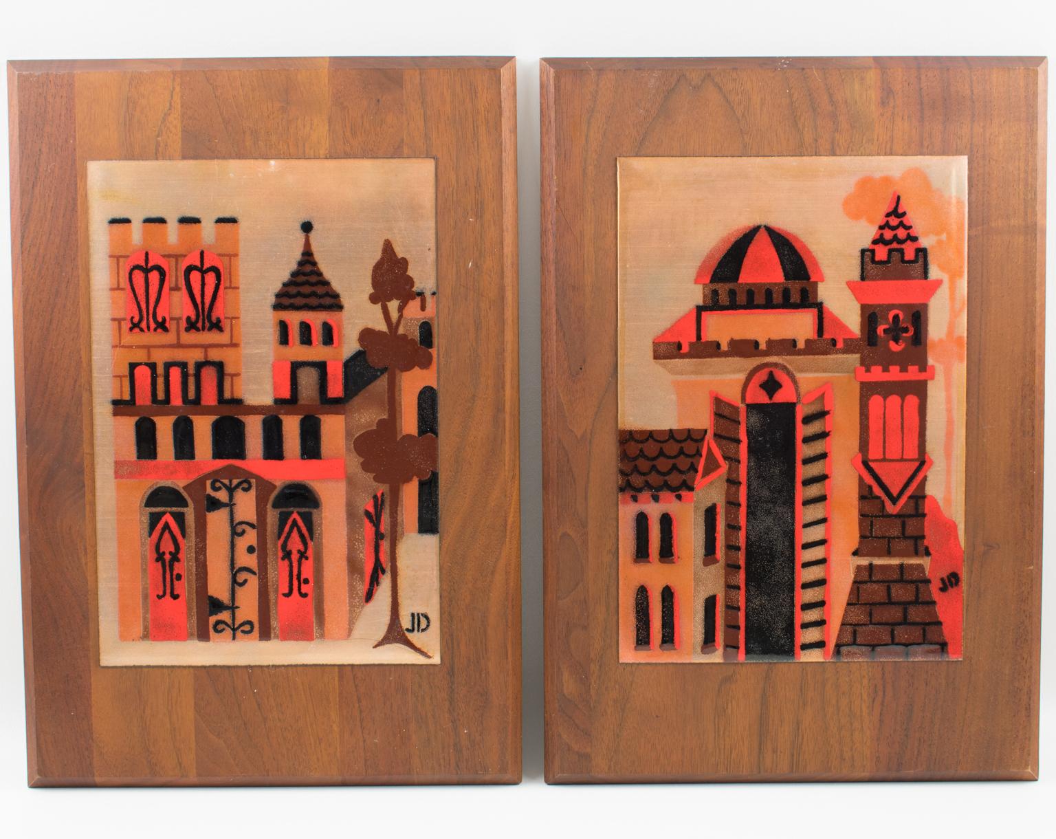 Judith Daner designed this pair of superb Mid-Century modernist enamel on copper artworks. Each panel is one tile plaque mounted on the original walnut wood frame. The abstract and stylized design features cityscape and various types of buildings.