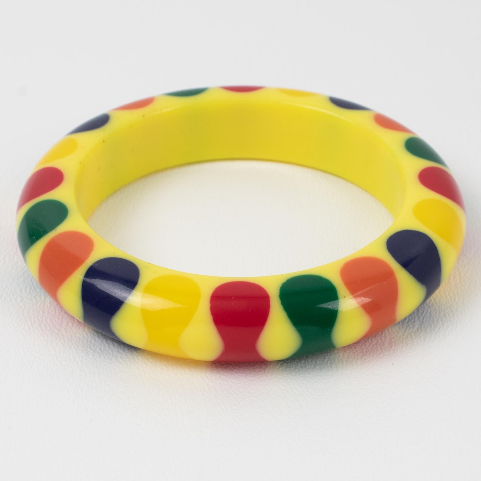 This lovely Judith Evans Lucite or resin bracelet bangle features an iconic gumdrop bowties design. The bracelet is set on a bright yellow background with multicolor laminated bowtie elements. Most of her creations are not signed except for a few