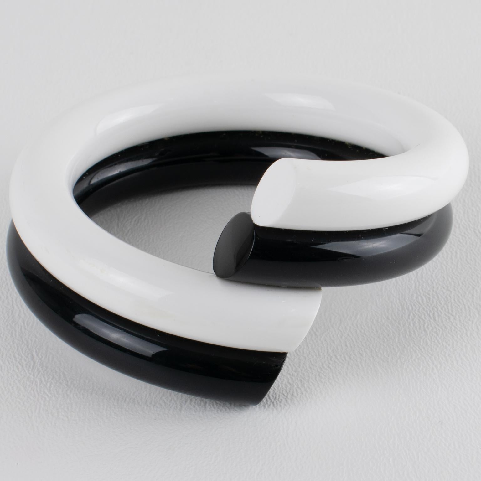 Judith Hendler designed this stunning Lucite or Acrylic bracelet bangle in the 1980s. It is a contrast of black and white with a coiled-wrapped design. 
Judith Hendler is a famous Californian jewelry designer from the 1980s. She created exquisite