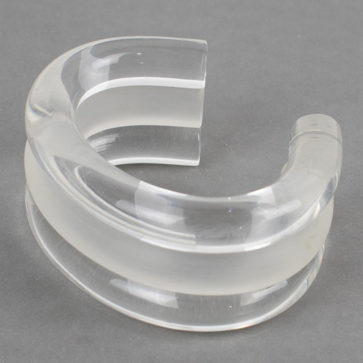 Judith Hendler designed this stunning lucite or Acrylic cuff bracelet in the 1980s. This rare bangle features a contrast of frosted and transparent colors and a triple-decker design. 
Judith Hendler is a famous Californian jewelry designer from the