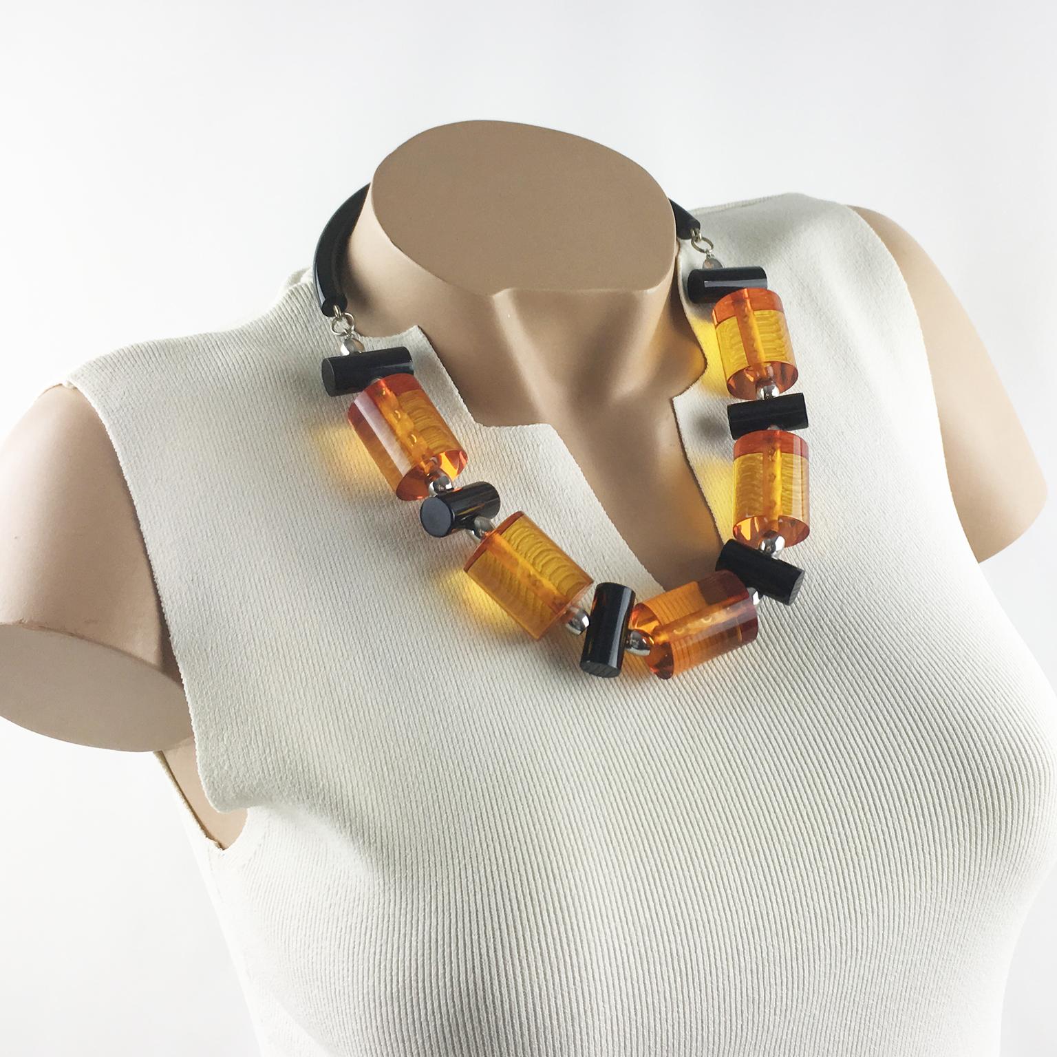This fabulous Judith Hendler necklace from the 1980s is a stunning jewelry masterpiece. It has the iconic acrylic or Lucite neck tube ring, and from it are elegant geometric large beads Acri-gems in assorted colors of transparent orange and true