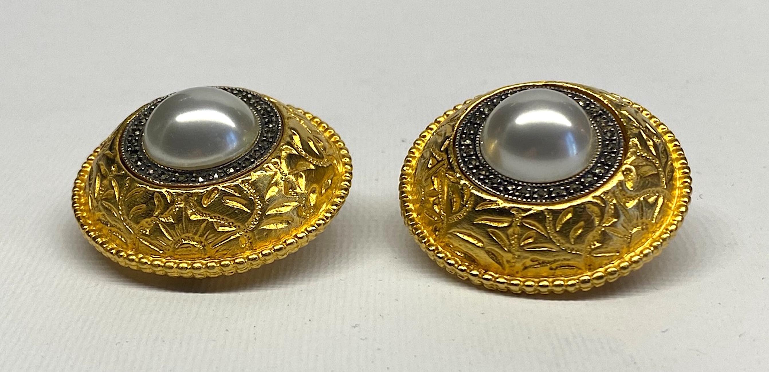 A truly lovely pair of elegant and large 1980s button earrings by Judith Jack. Each earrings is 1.38 in diameter and .63 of an inch high not including the clip back. A large central 14 mm faux pearl cabochon is mounted into a sterling silver setting