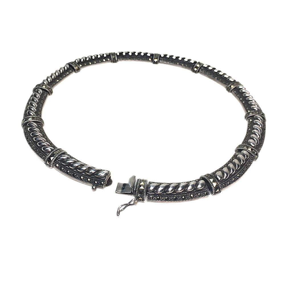 This is a signed JJ sterling & marcasite choker. This twisted rope design oxidized sterling silver choker has decorated marcasite round and square cut stones projecting low key luxury. The 12 linked sections are completed with a security clasp.