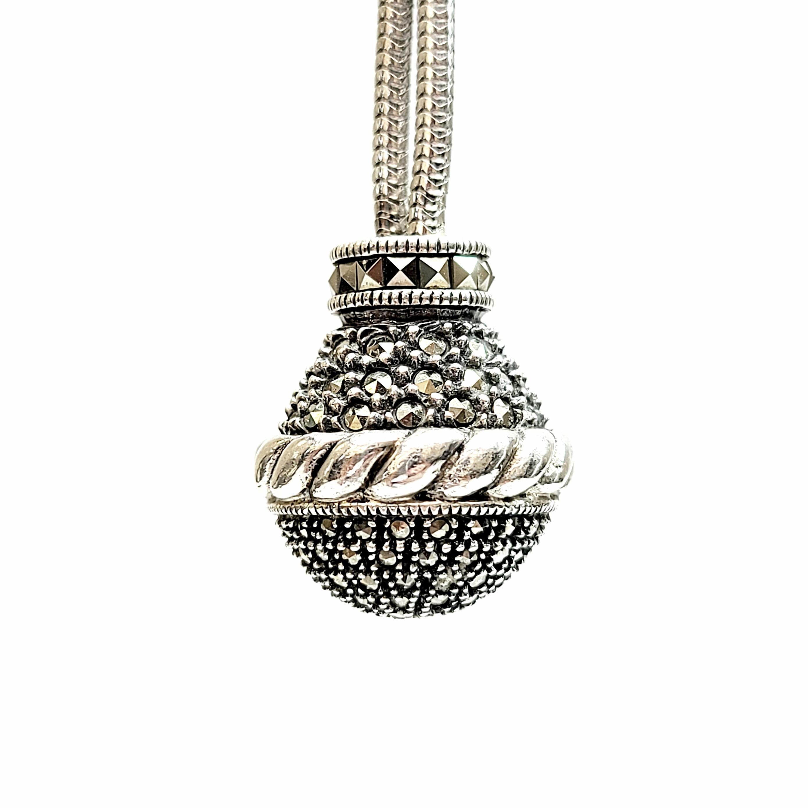 Judith Jack sterling silver and marcasite ball pendant necklace.

A marcasite encrusted ball pendant with rope texture detail hangs from a double snake chain with a rope textured and marcasite bead-like accent.

Chain measures approx 33