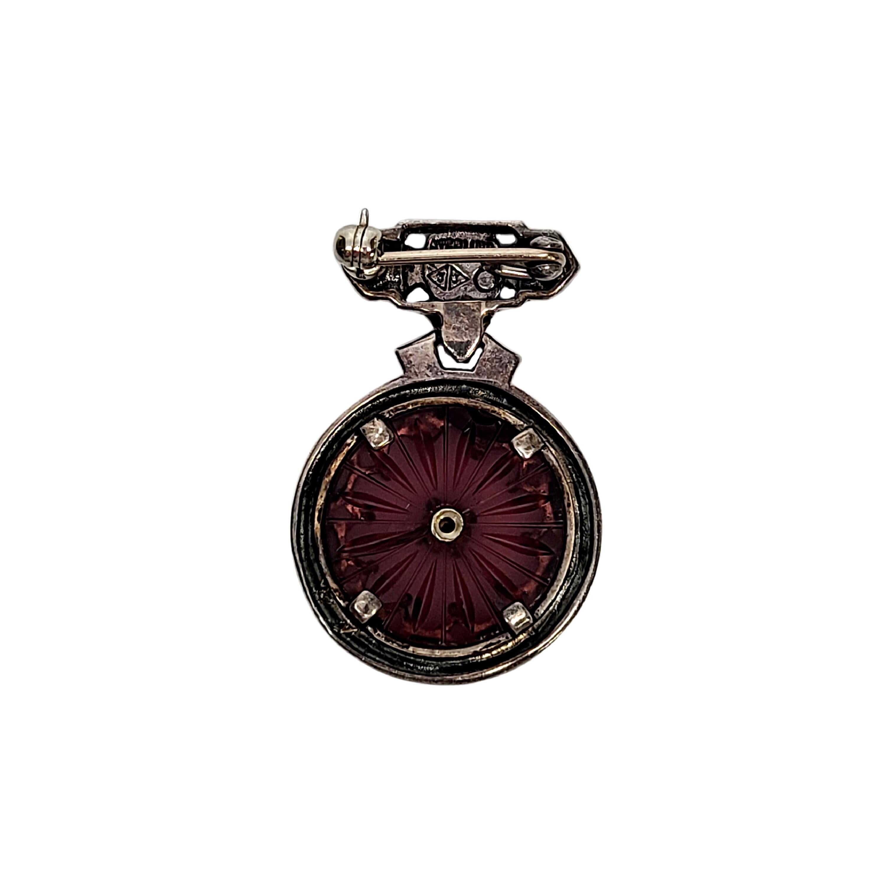 Sterling silver, marcasite and purple camphor glass pin by Judith Jack.

Beautiful art deco design features purple camphor glass framed in marcasite encrusted sterling silver. Features a small bezel set marcasite at its center.

Measures 1 3/8