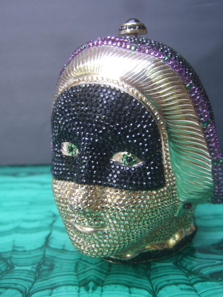 Judith Leiber Exquisite crystal encrusted figural woman minaudiere'
The opulent gilt metal figural evening bag is designed with an elegant woman's head. Encrusted with contiguous rows of intricate tiny handset Swarovski crystals 

The opulent