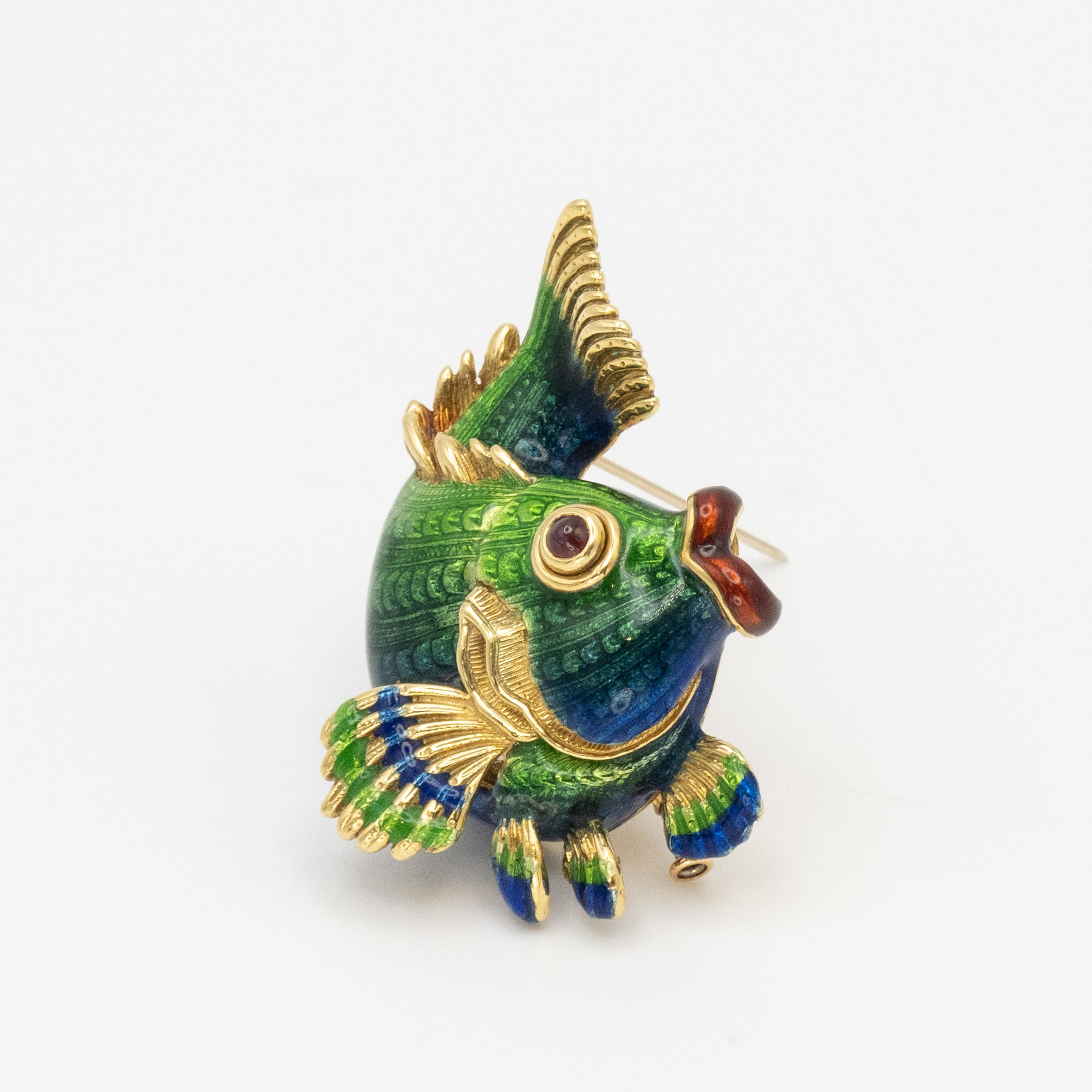 Stunning JUDITH LEIBER 18k yellow gold enamel fish brooch with beautiful colorful enamel in blue & green hues over a lively fish with cabochon ruby eye. The brooch is extremely well made with cut out backing.

The brooch has a single pin closure &