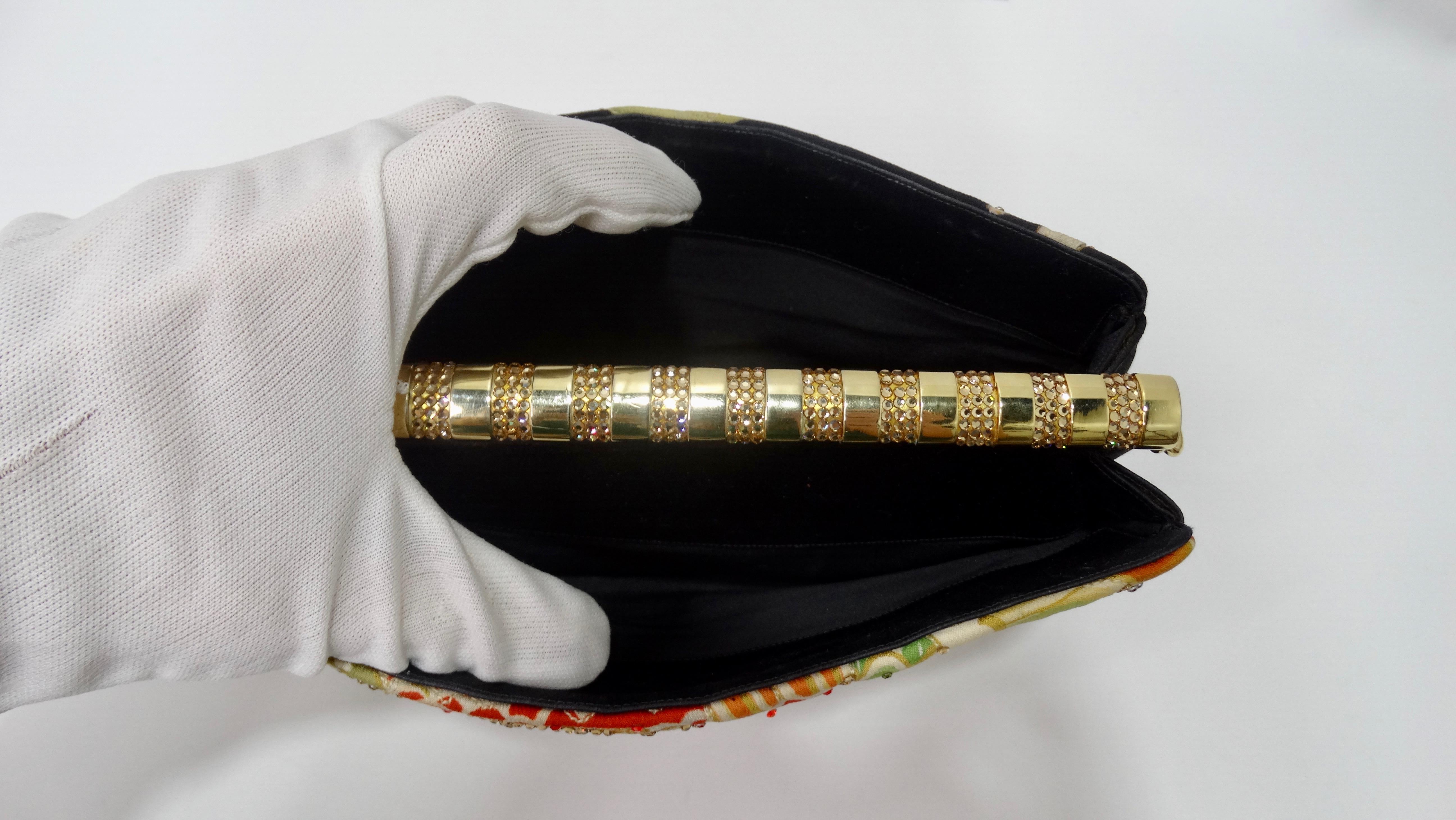 Take on the evening with this stunning Judith Leiber clutch! Circa 1970s, this clutch features a beautiful Asian motif finished with glittering multi-colored rhinestones, two exterior pockets and a gold plated top closure with rhinestones. Interior