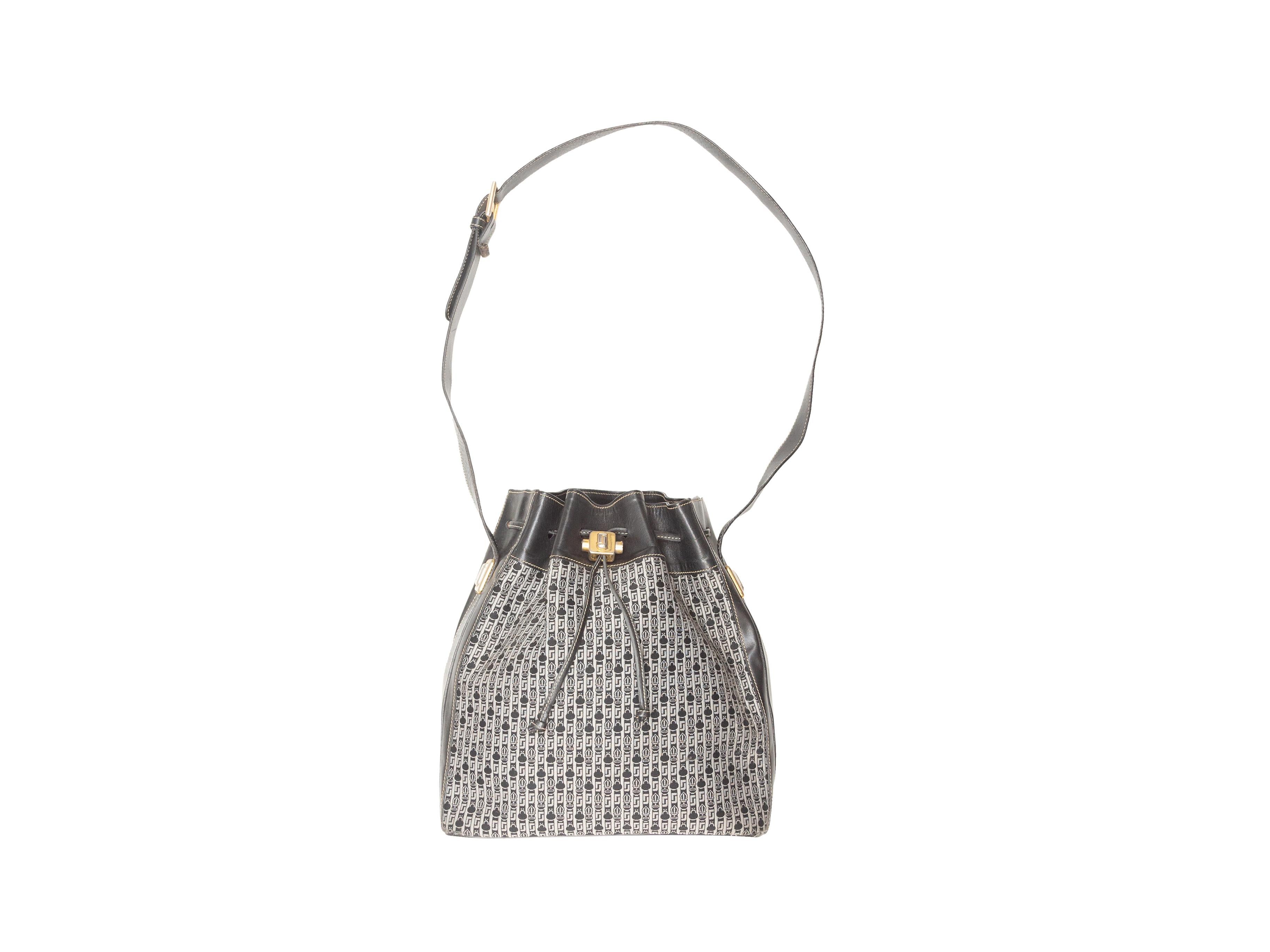 Product Details: Vintage Black & Grey Judith Leiber Bucket Bag. This bag features a canvas body, leather trim, gold-tone hardware, a single flat adjustable shoulder strap, and a drawstring closure at the top. 10