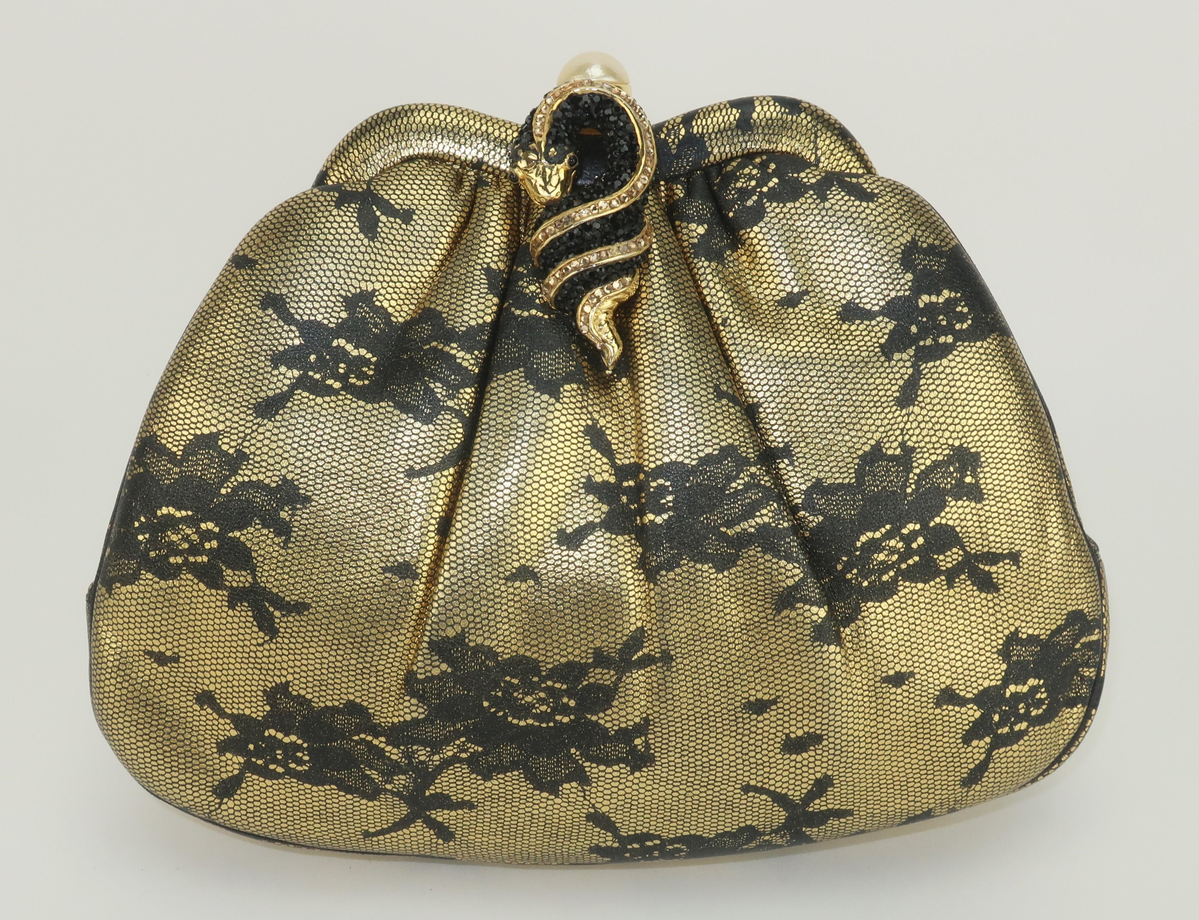 Vintage Judith Leiber evening handbag in an unusual black lace printed gold leather with a push button pearl closure embellished by a coiled pave crystal snake.  The closure opens to reveal a satin lined interior with two open side pockets and a