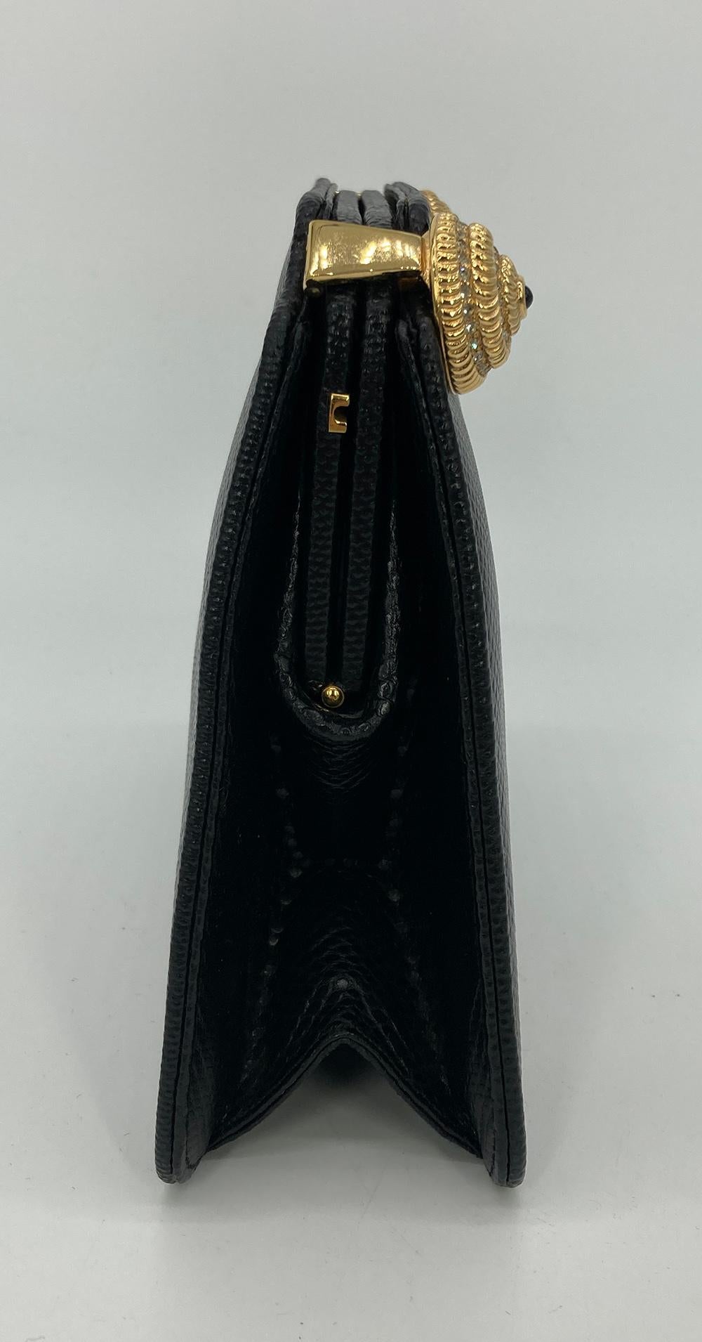 Judith Leiber Black Lizard Crystal Shells Clutch in very good condition. Black lizard exterior trimmed with gold shells covered in clear crystals. The shells lift up to open this piece revealing a black satin interior with one slit and one zipped