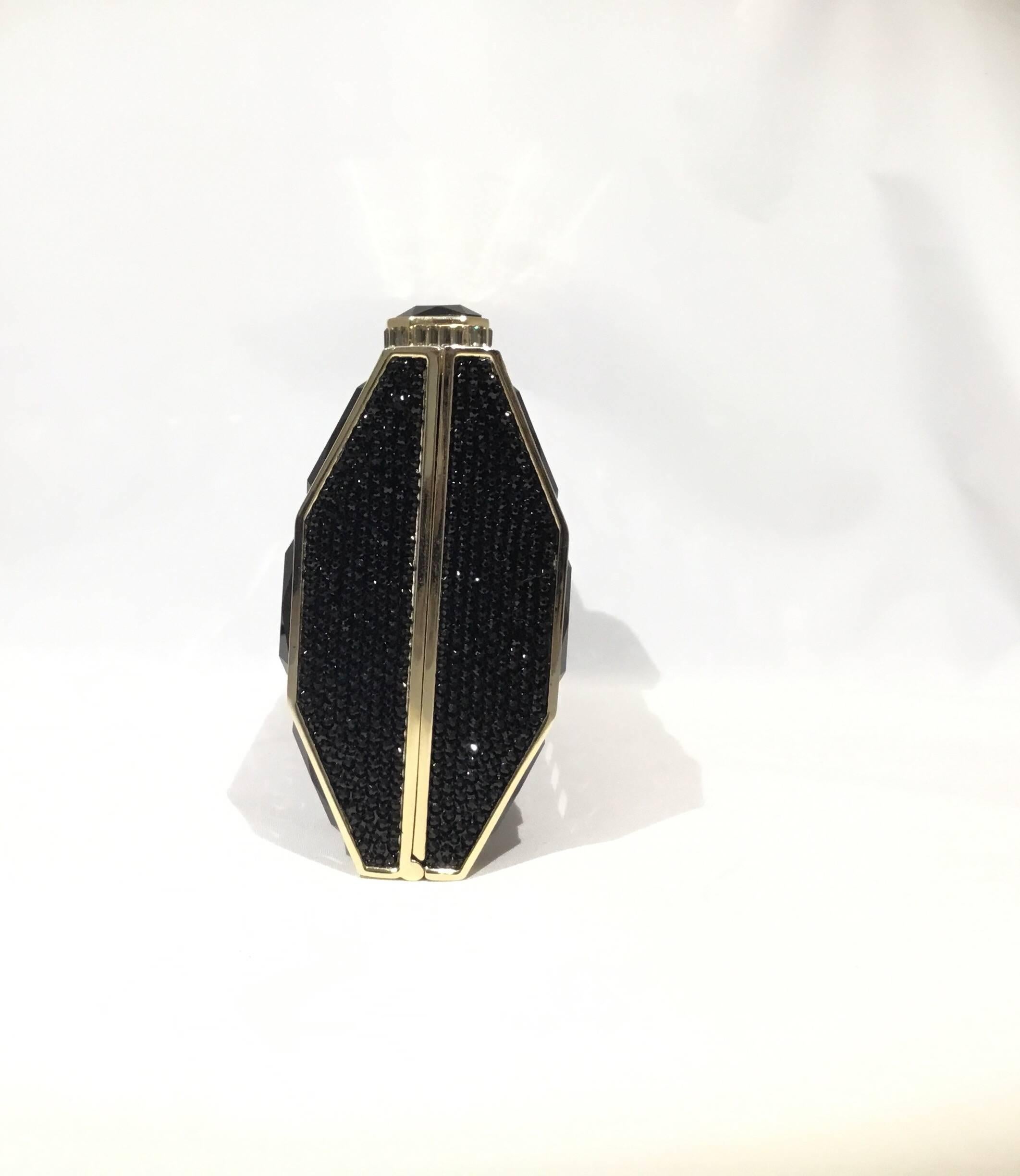 Judith Leiber evening clutch features large black crystals throughout with a top push lock closure and an optional gold shoulder strap. Interior is fully lined in a metallic gold leather. Excellent condition.

Measurements are as follows:
6.5'' x