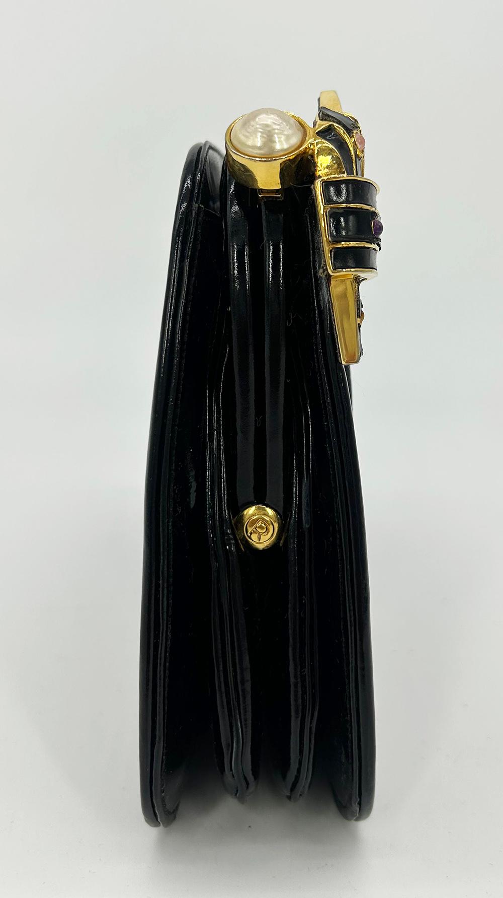 Judith Leiber Black Patent Leather Clutch in good vintage condition. Black patent leather in unique diagonal pleated design along front side trimmed with gold hardware. Black enamel and gold knot hardware detail along top front right with tiny multi
