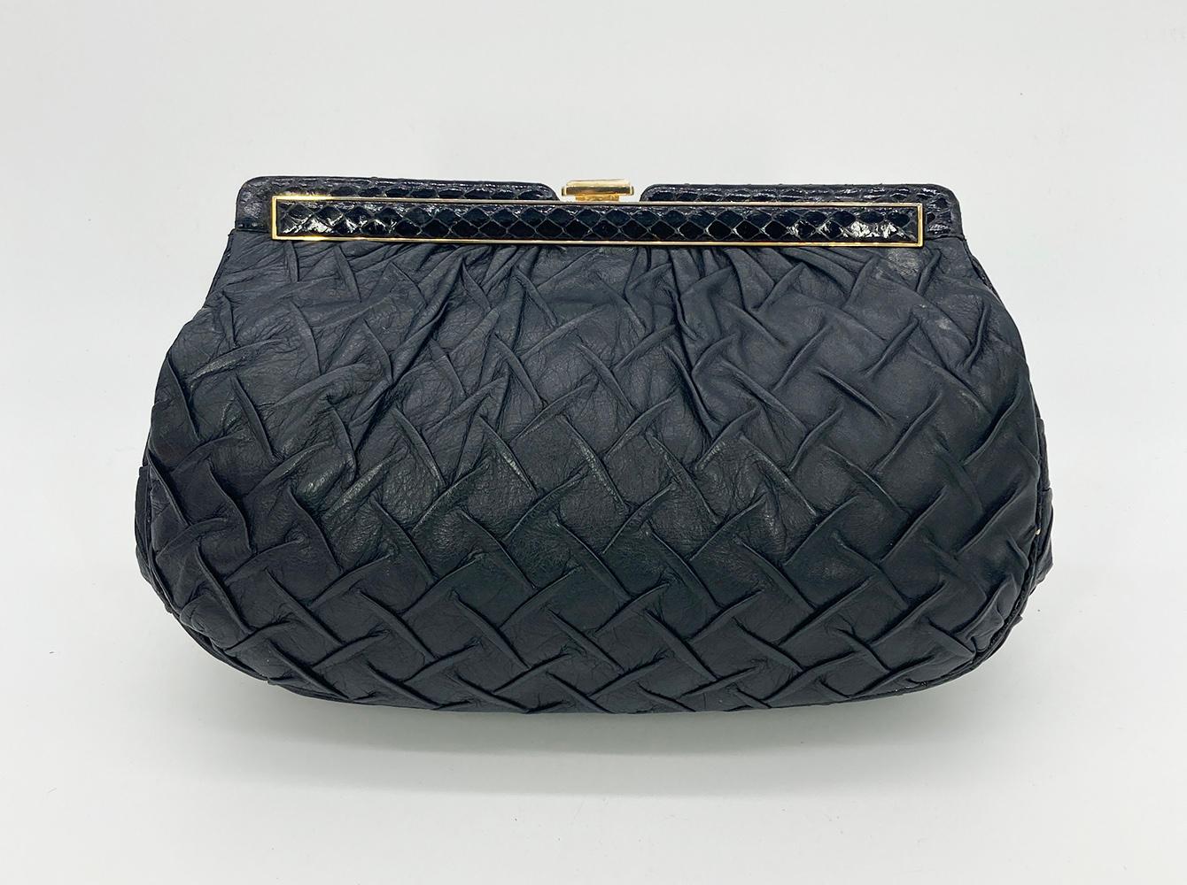 Judith Leiber Black Pleated Leather Resin Bone Top Clutch in very good condition. Black soft lambskin exterior in unique crisscross pinch pleated design trimmed with gold hardware, black snakeskin and distressed resin bone accent along top edge. Top