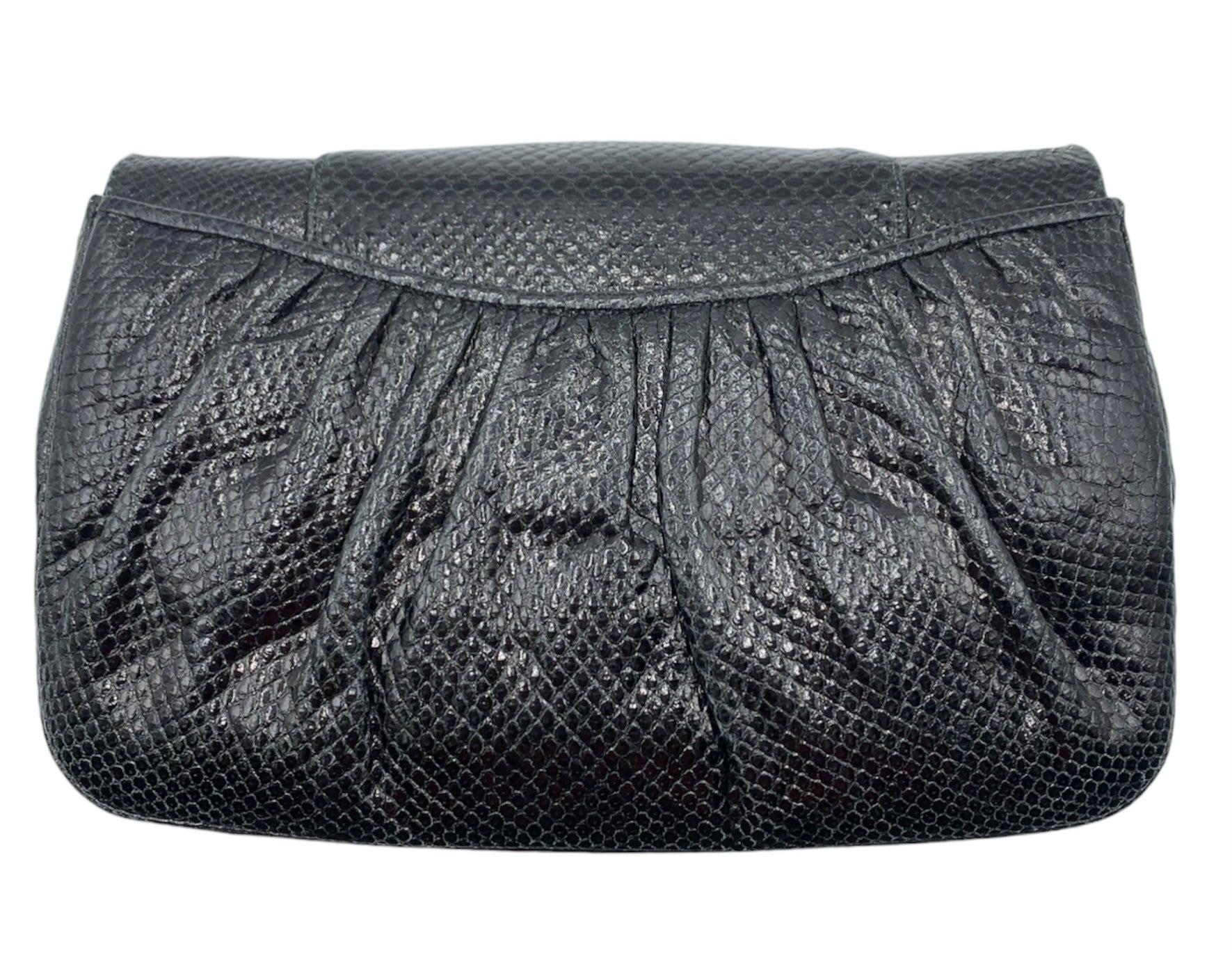 Expertly designed by renowned handbag designer Judith Leiber, this 80s black reptile deco evening bag exudes elegance with its unique styling. The hidden removable leather strap allows for versatile wear, making it the perfect accessory for any