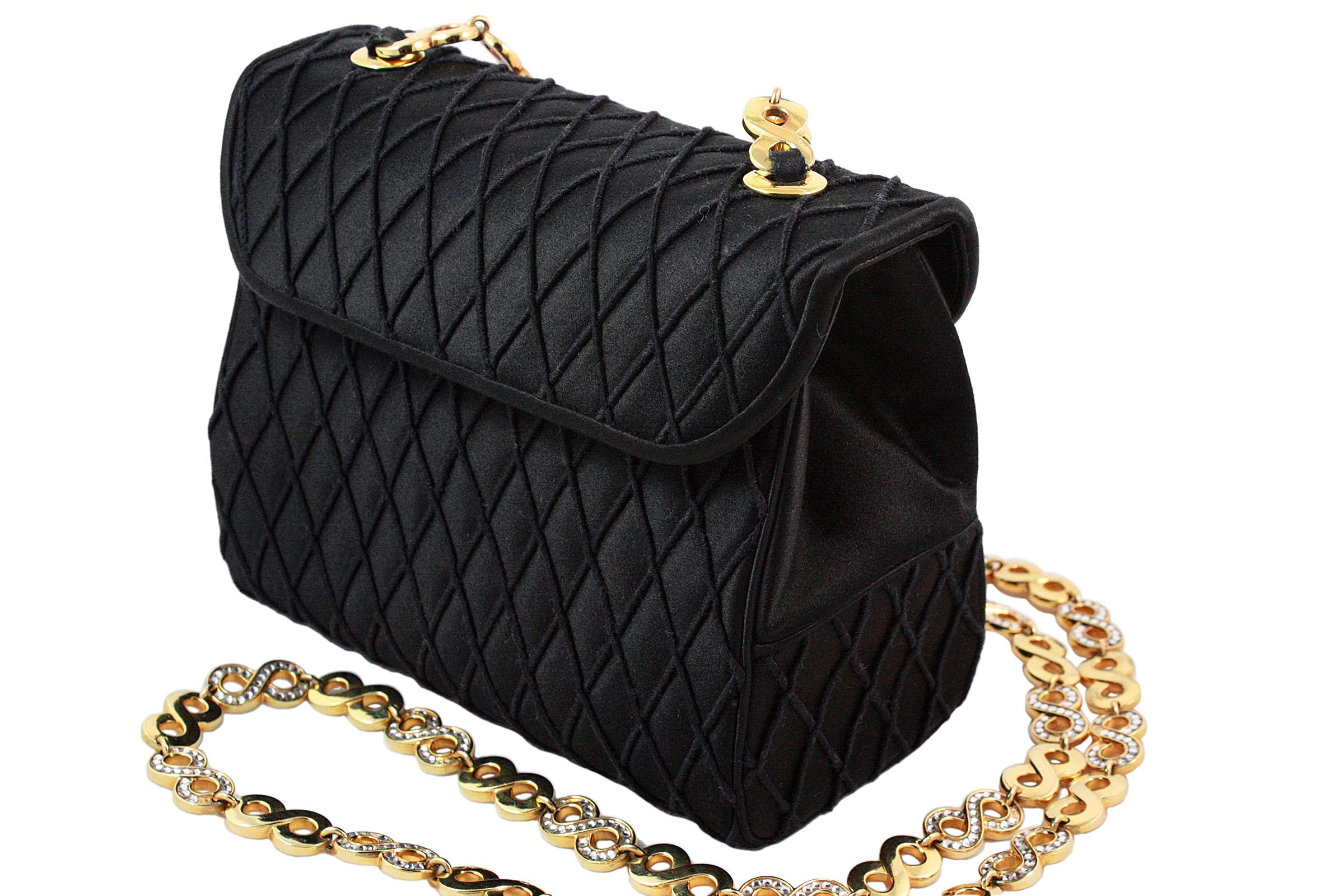 Judith Leiber crossbody bag 
Black satin with diamond thread pattern 
Hidden gold snap closure 
Gold rhinestone infinity chain strap 
Black satin lining
Inner card slot and zippered pocket
Comes with black coin purse, gold mirror and blue dust-bag 
