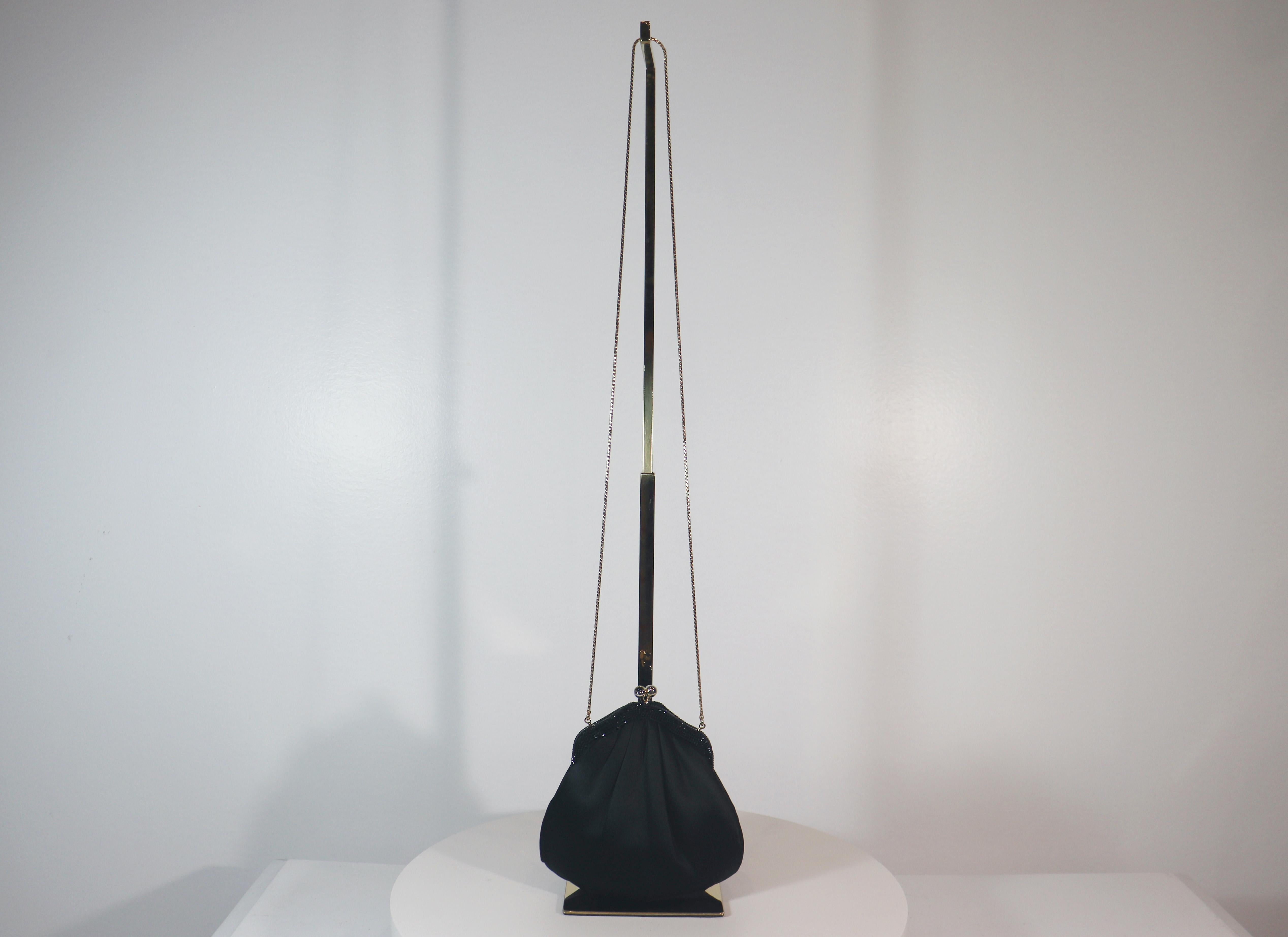 Judith Leiber black satin evening bag with jet black rhinestones. This evening bag is in 'LIKE NEW' condition. There are no significant flaws or wear areas to consider with this lovely evening bag. It had been very gently used and carefully stored