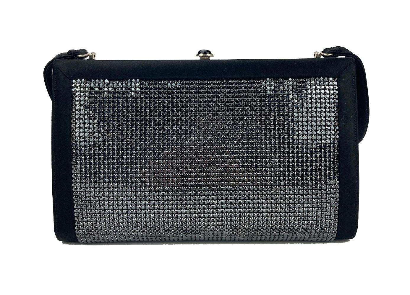 Judith Leiber Black Silk Black Rhinestone Evening Bag in excellent condition. Black silk exterior trimmed with sparkling black rhinestone body, silver hardware and black silk shoulder strap. Top button hinge closure opens to a matching black silk