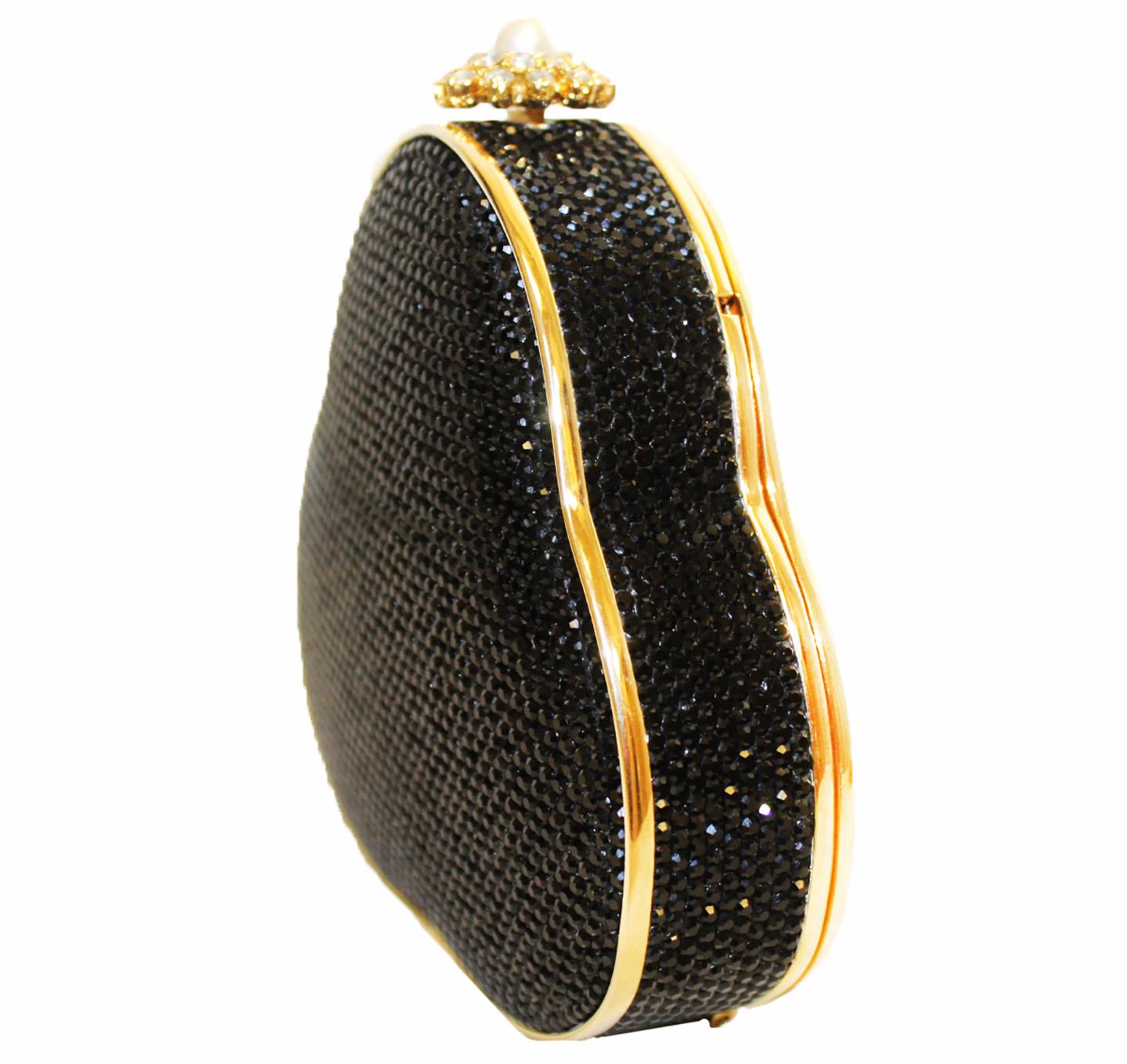 Judith Leiber black Swarovski crystal exterior trimmed with gold tone hardware and faux pearl top push button closure. Gold tone leather lined interior that holds a gold chain shoulder strap to easily convert between clutch and shoulder styles. 