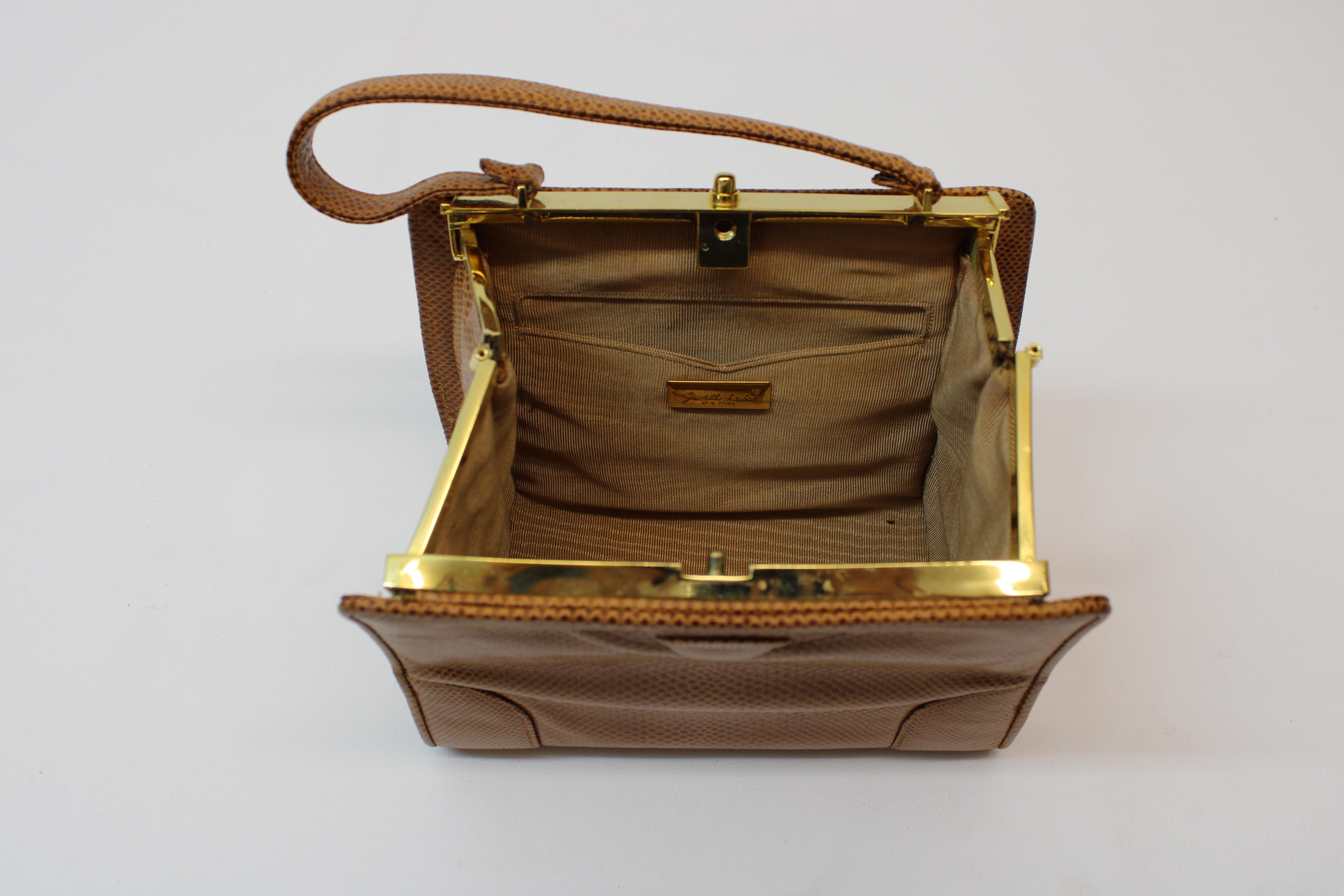 Adorable Judith Leiber brown lizard purse/satchel w/ gold tone hardware, this purse has a clasp to open and close & a cute handle. The Purse comes with a few item's that are a must need ( Compact mirror, small comb & coin holder ).