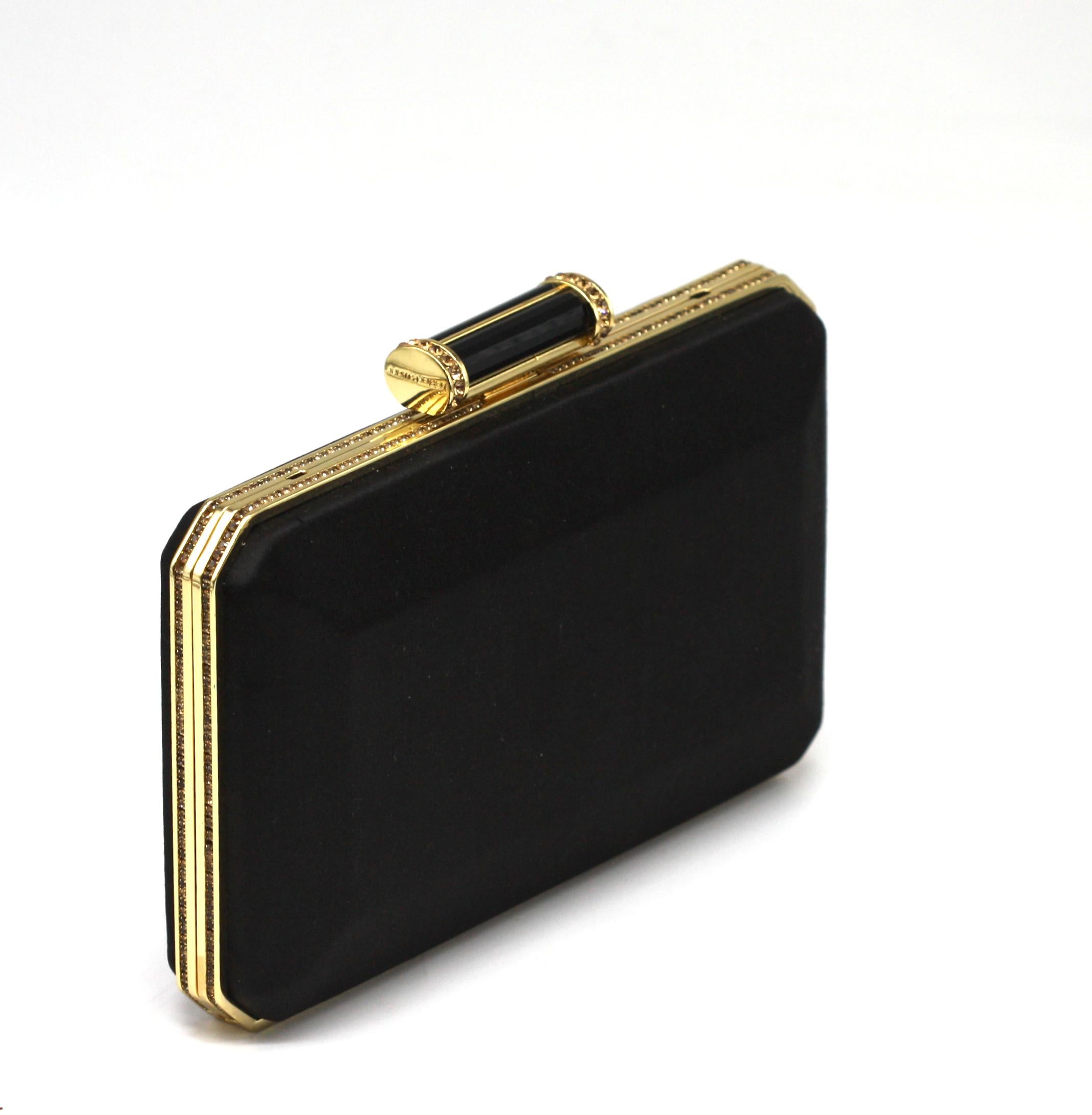 Judith Leiber Couture - Pochette en satin noir avec bordure dorée et fermeture à bouton-pression



Cette pochette structurée de Judith Leiber Couture, élégante et raffinée, est réalisée en satin noir lisse, avec des lignes géométriques nettes et