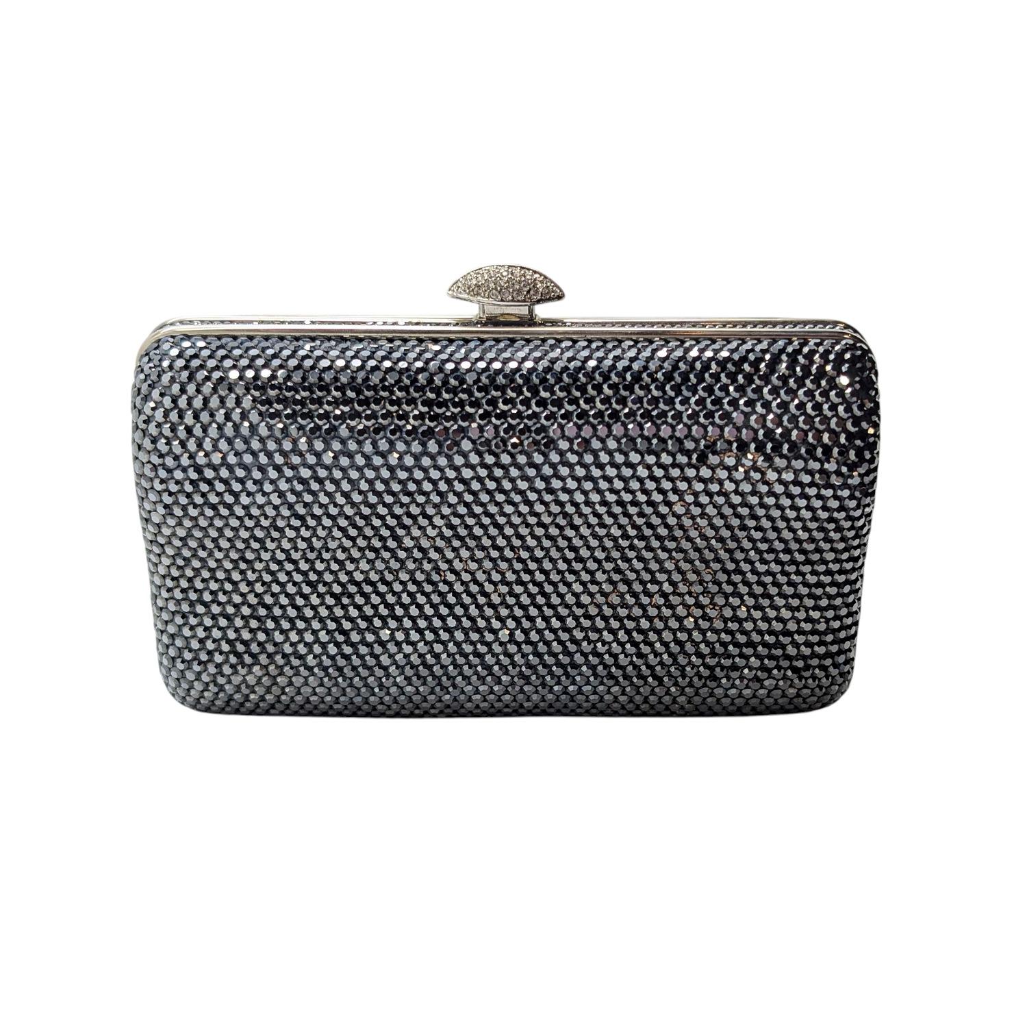 Elevate your evening look with the Judith Leiber Swarovski Crystal Minaudiere Clutch, dazzlingly encrusted in hematite colored crystals for a striking statement. This compact hard-shell bag features a sleek silver chain strap and a secure push-lock
