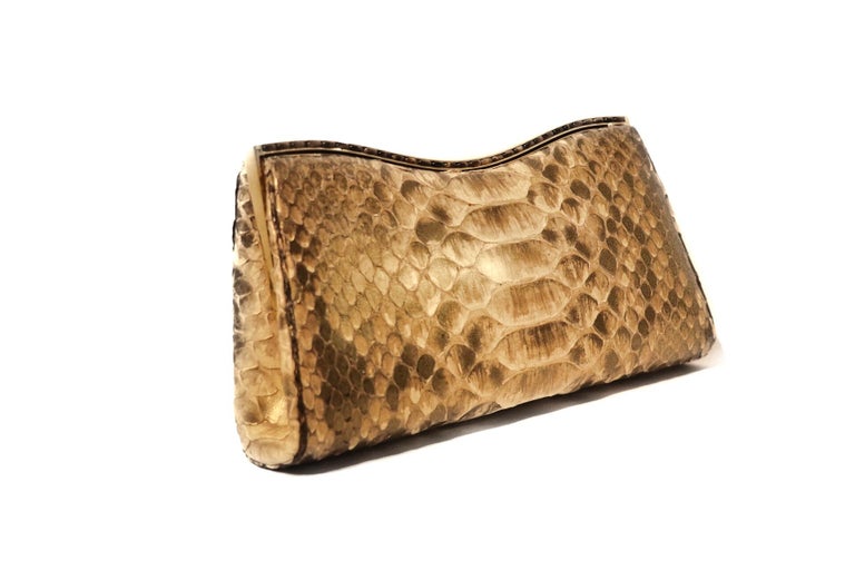 This authentic Judith Leiber Metallic Python Evening Clutch is in pristine condition.  Neutral exotic skin clutch carries just the essentials for an evening out on the town.  Light tinted metallic sheen. 
Vanity mirror, comb and small purse