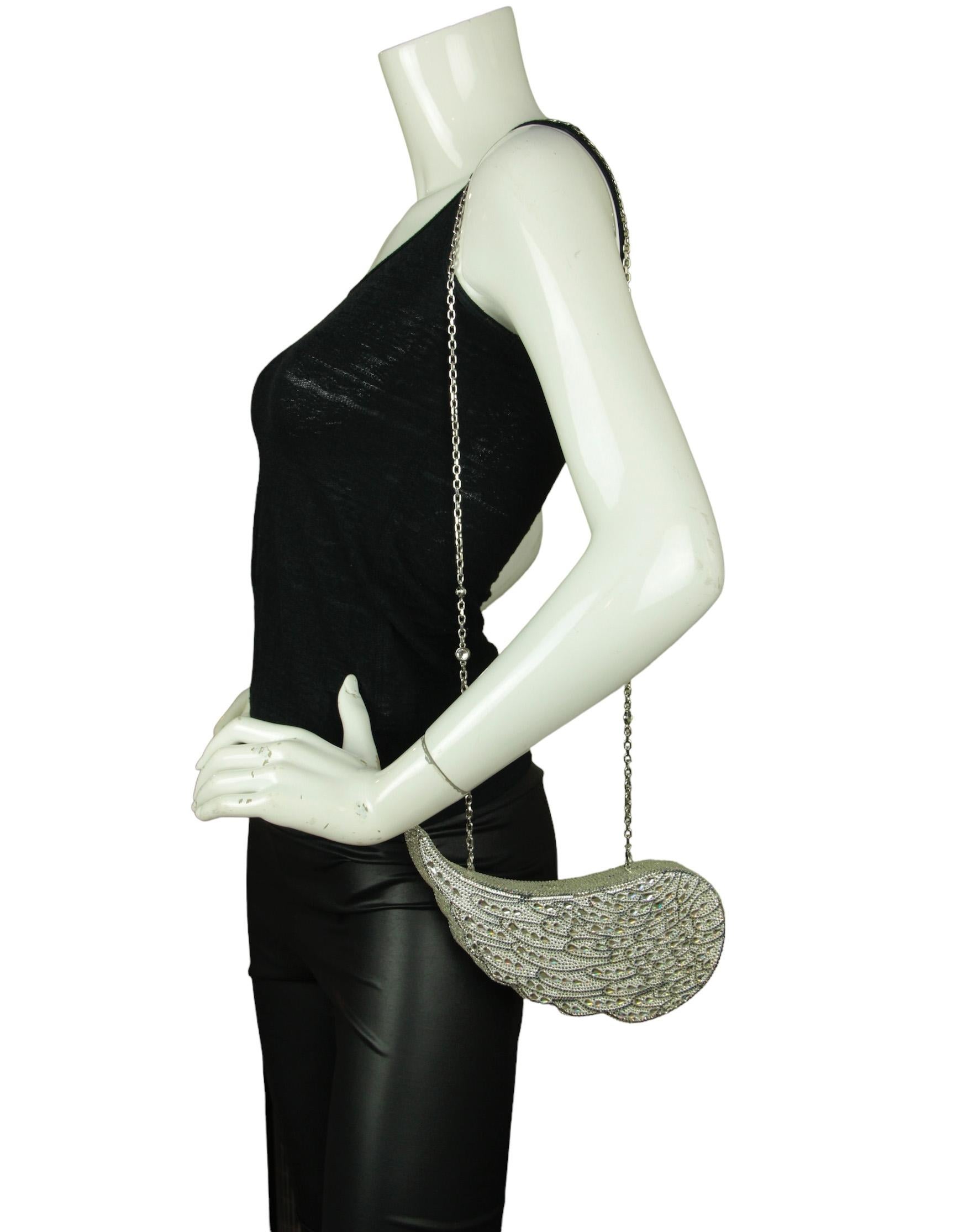 Judith Leiber Crystal Angel Wing Minaudiere Clutch Bag. Features detachable chain strap

Hardware: Silvertone
Materials: Crystals, metal
Lining: Silver leather 
Closure/Opening: Frame closure
Exterior Pockets: None
Interior Pockets: None
Exterior